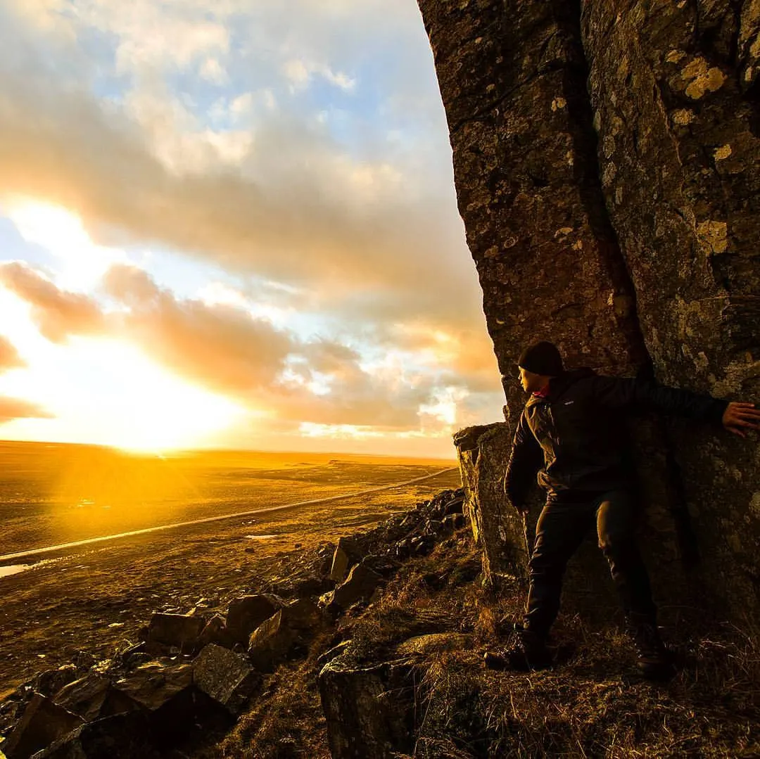 Angelito Jusay on a rocky cliff at sunset during his travels