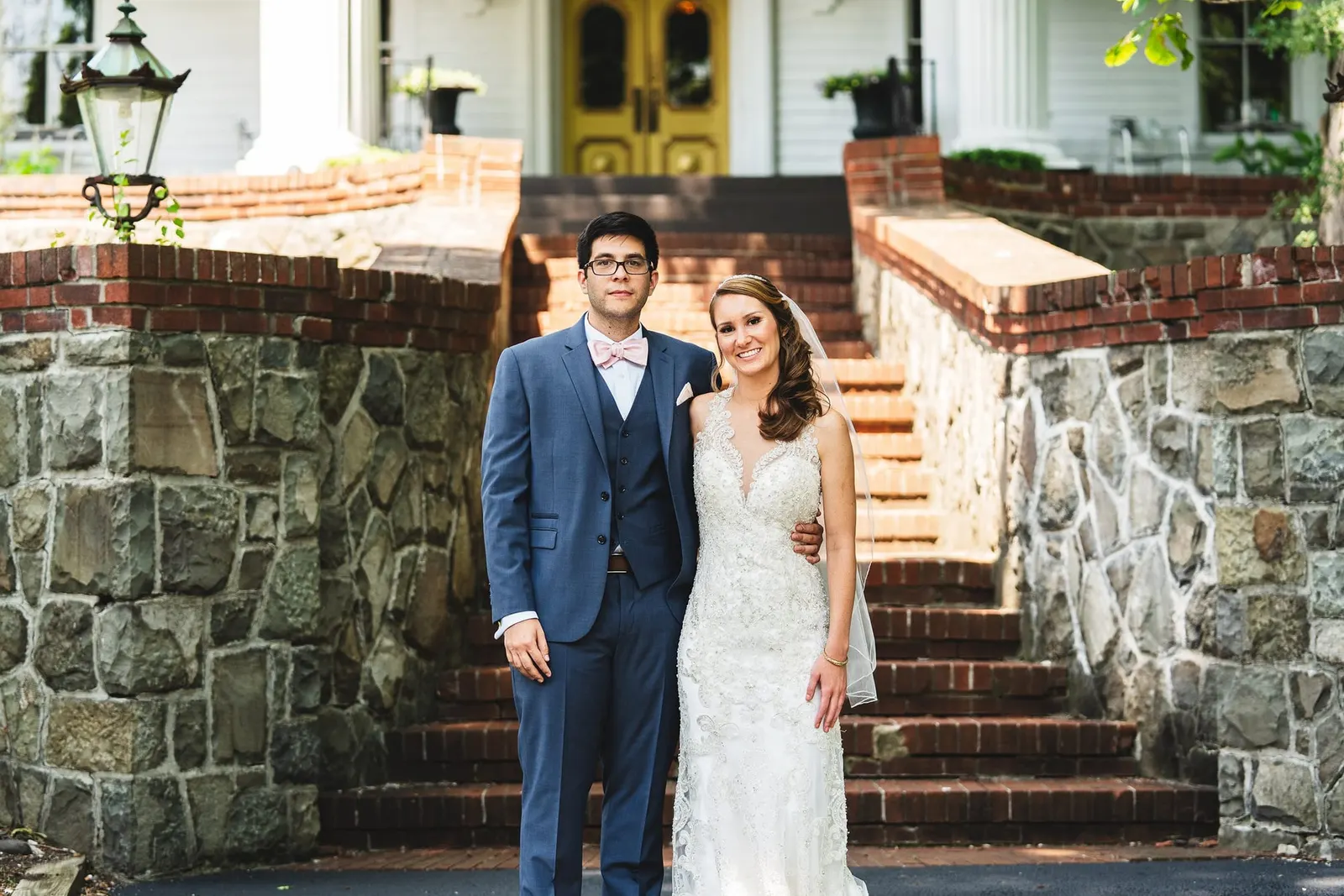 Bride and groom at the foot of the brick and stone steps