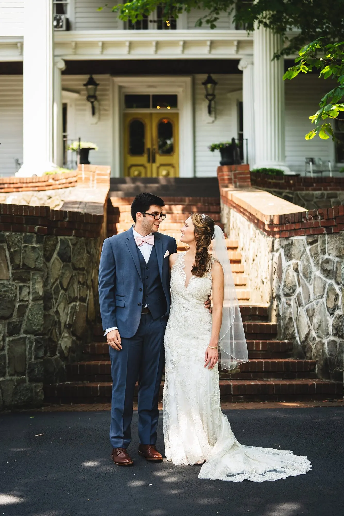 Bride and groom in front of the farmhouse entrance at Feast at Round Hill