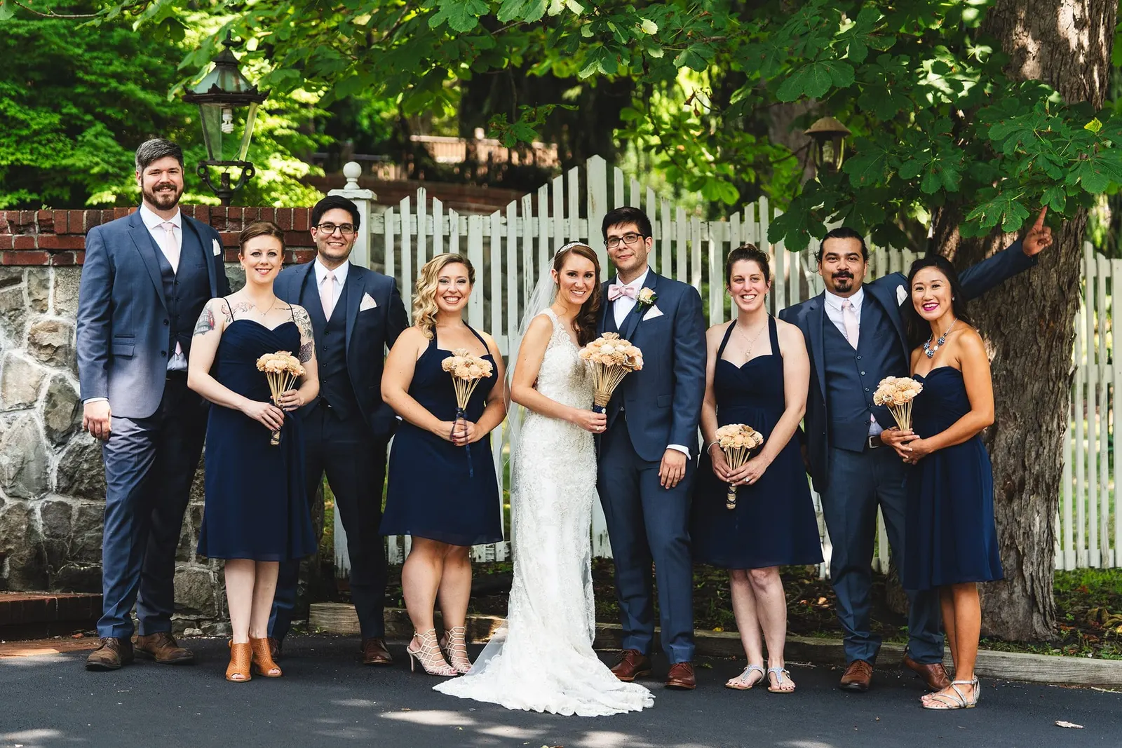 Wedding party laughing together by the stone wall