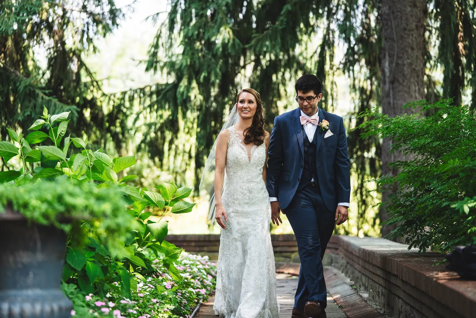 Bride and groom walking through the gardens