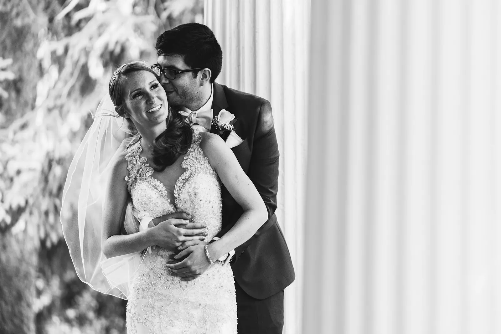 Black and white portrait of the bride and groom embracing