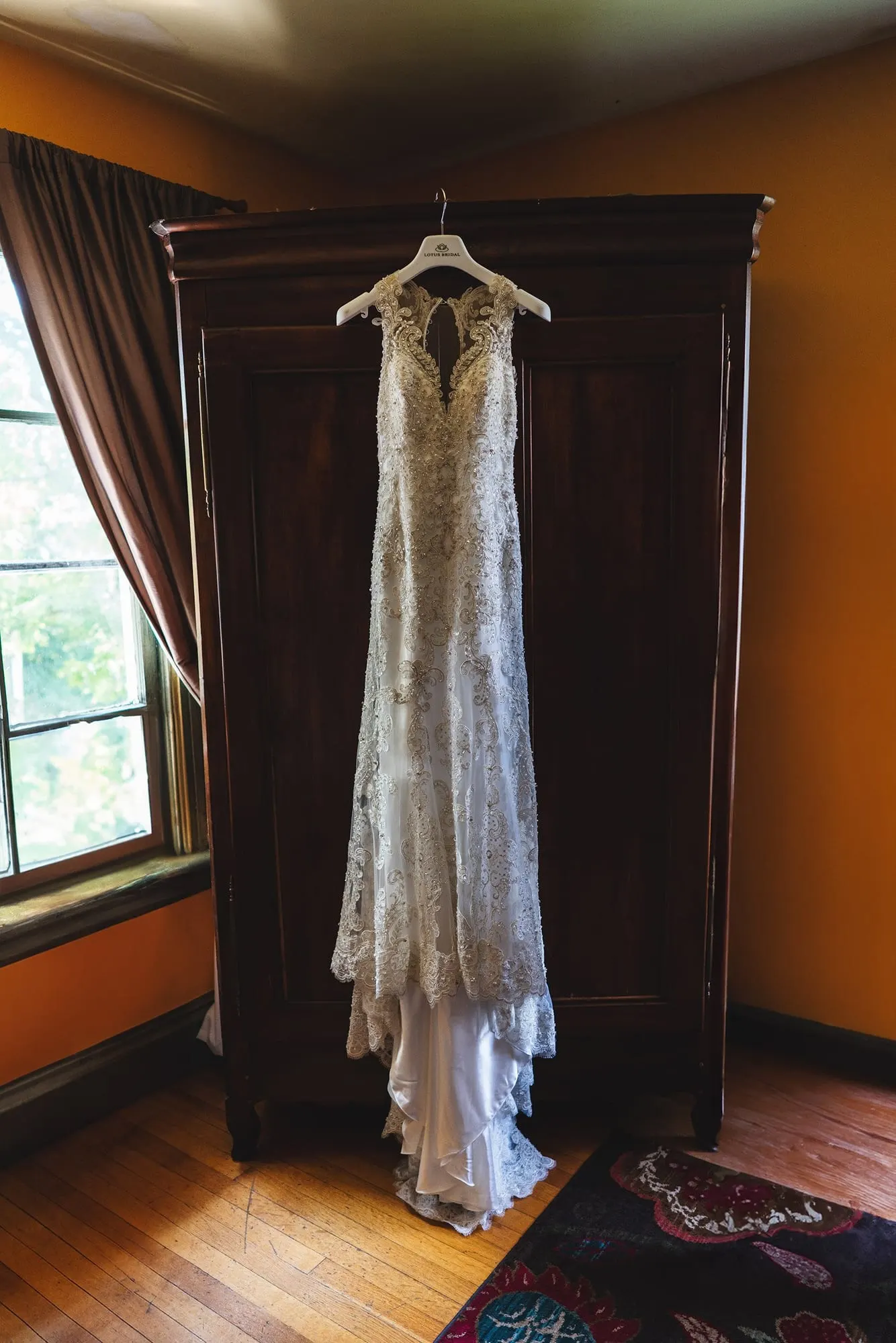 Wedding gown hanging in a sunlit farmhouse bedroom at Feast at Round Hill