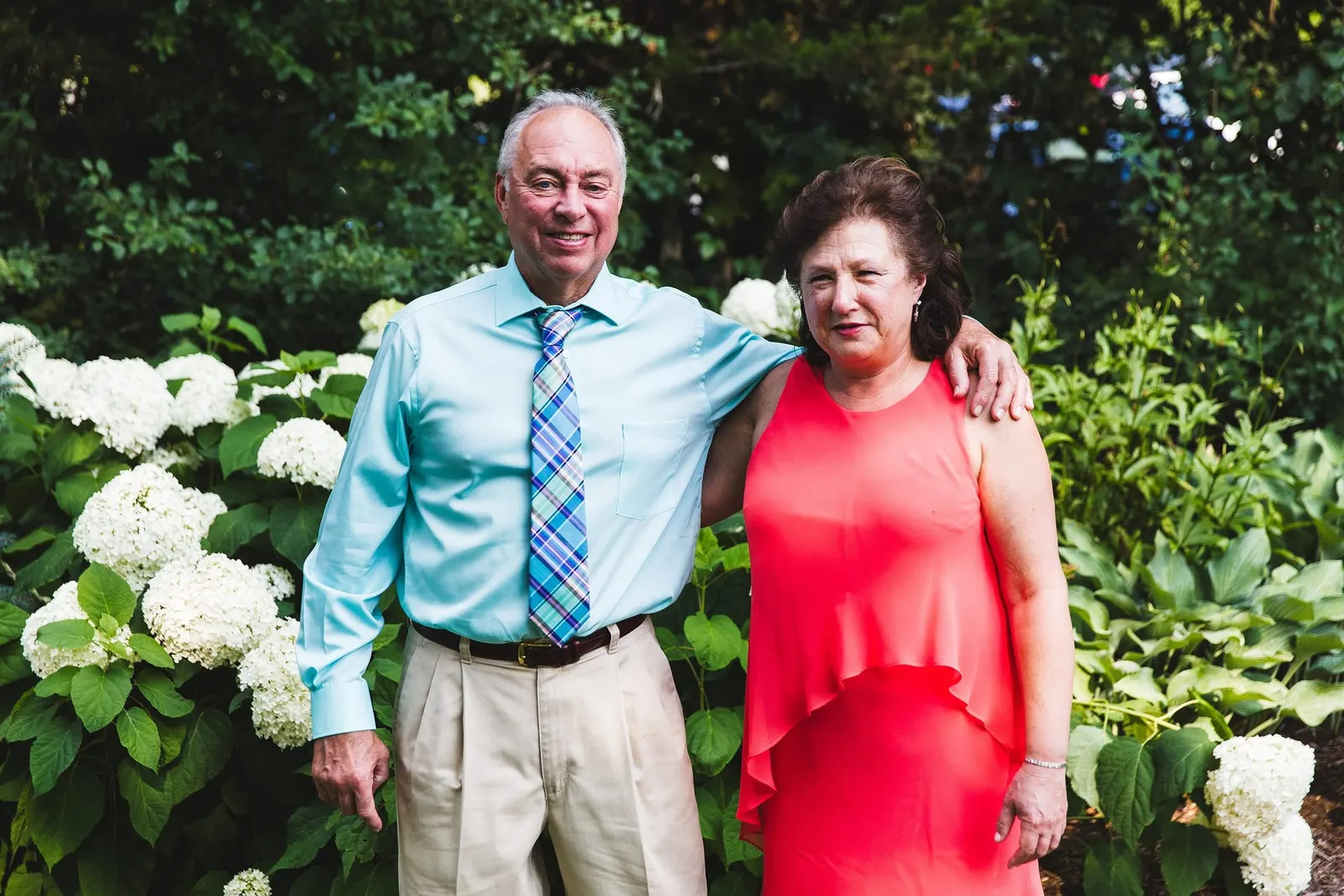 Family members smiling by white hydrangeas