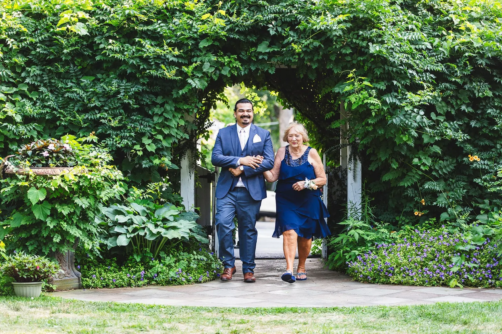 Processional walking through the ivy arch toward the ceremony