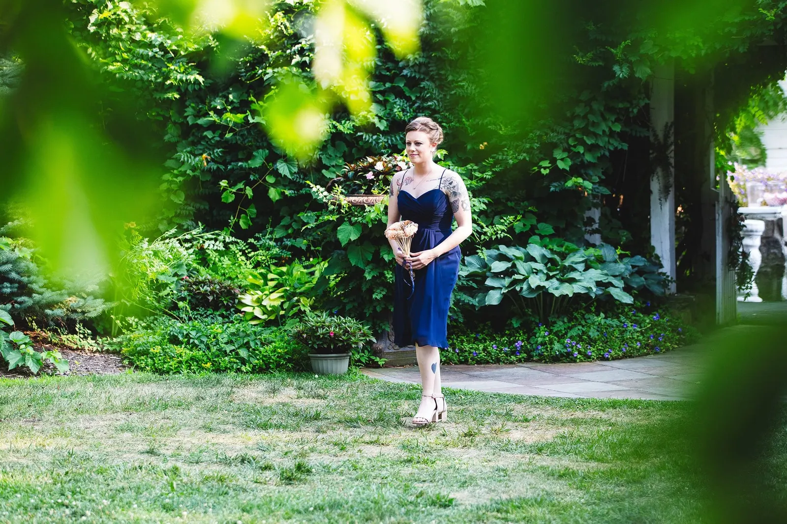 Bridesmaid walking toward the ceremony through the garden