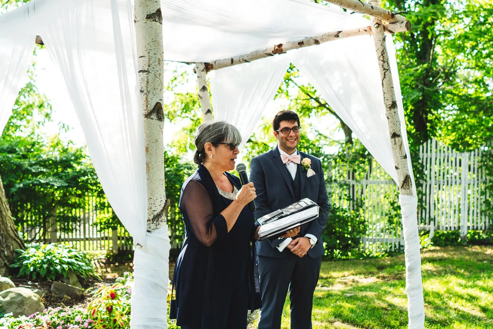 Officiant and groom waiting under the birch arbor