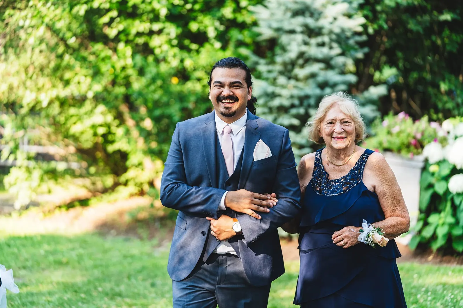 Smiling processional down the lawn aisle