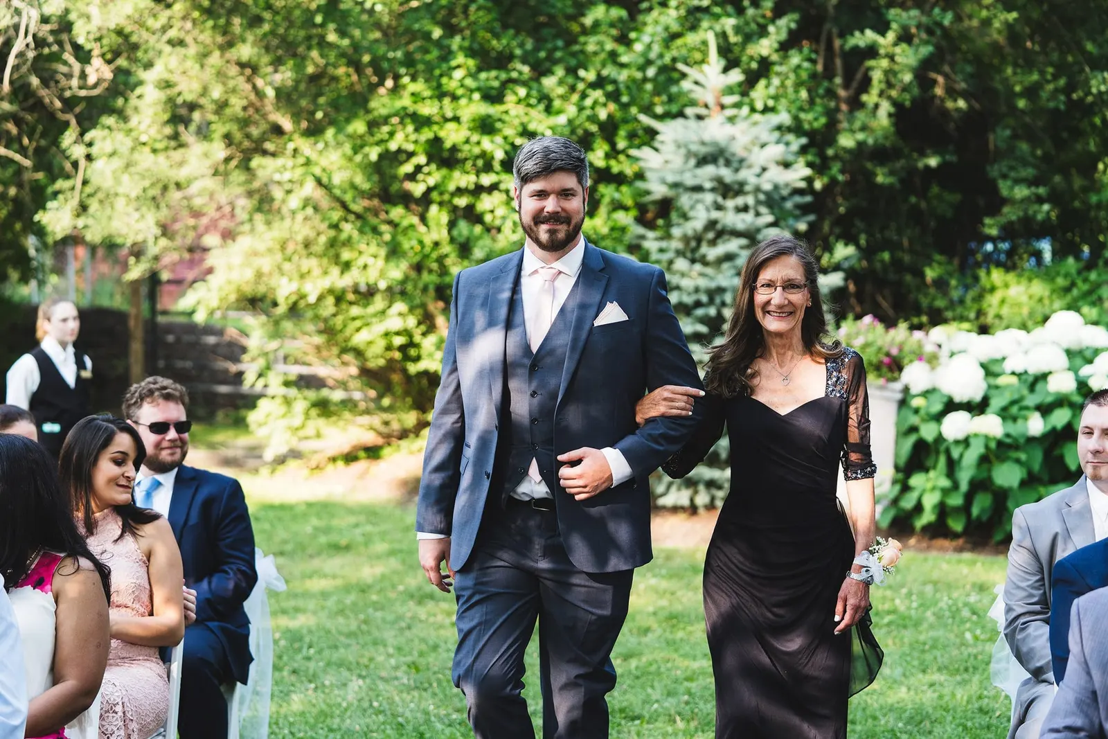 Processional pair walking down the lawn aisle