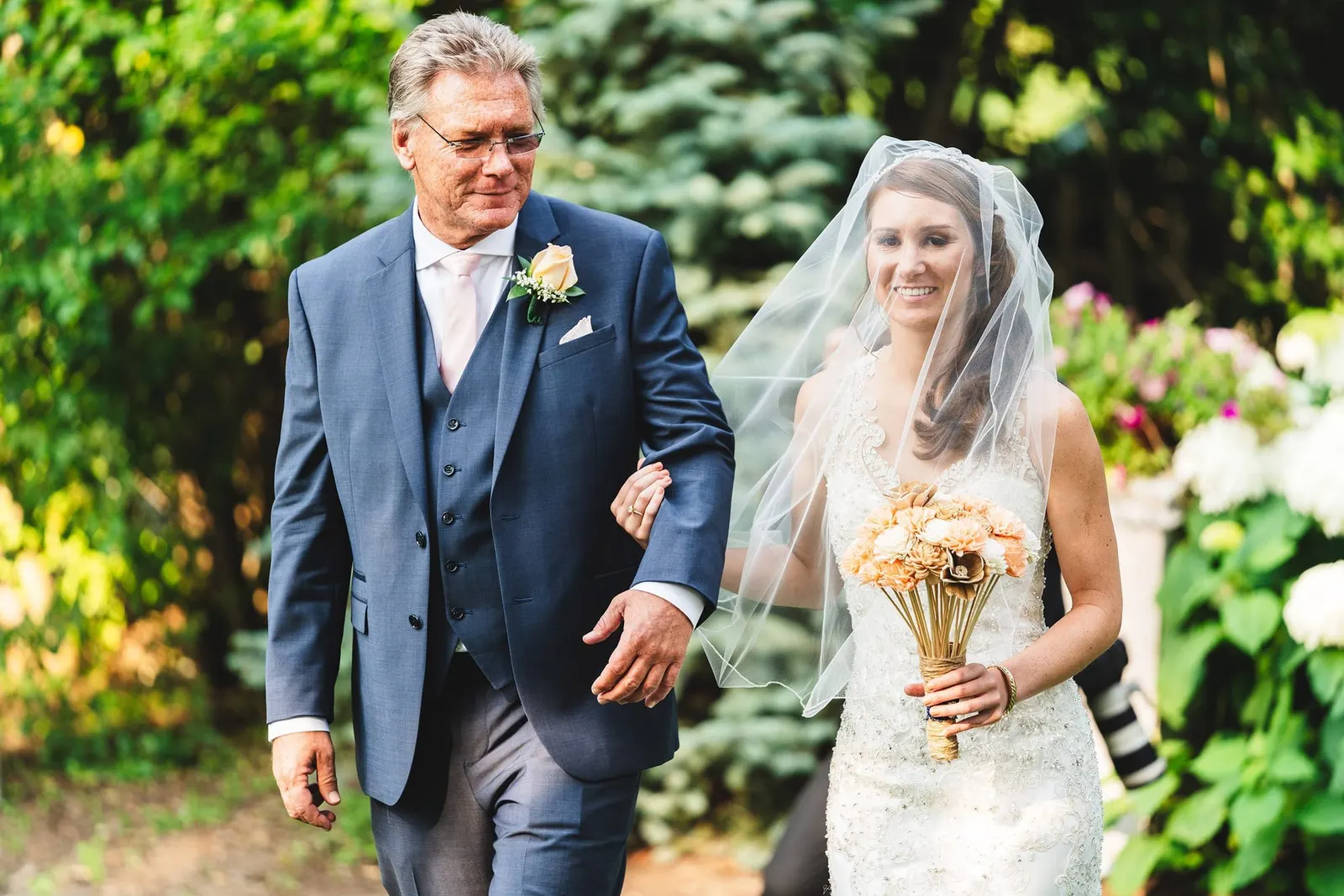 Bride being escorted down the aisle with her bouquet