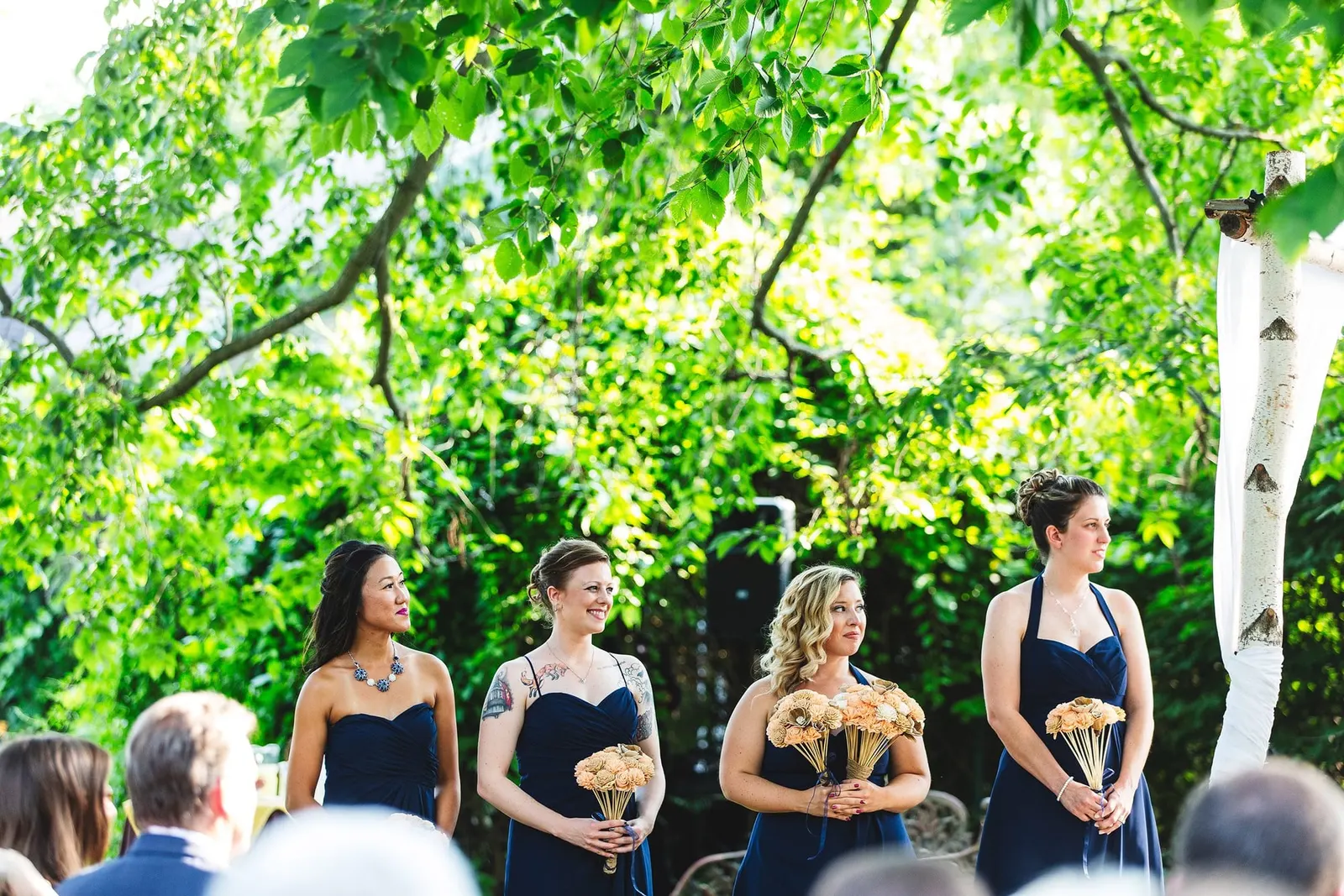 Bridesmaids in navy standing during the ceremony