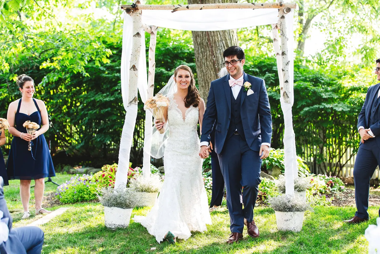 Newlyweds beginning their walk back up the aisle from the birch arbor