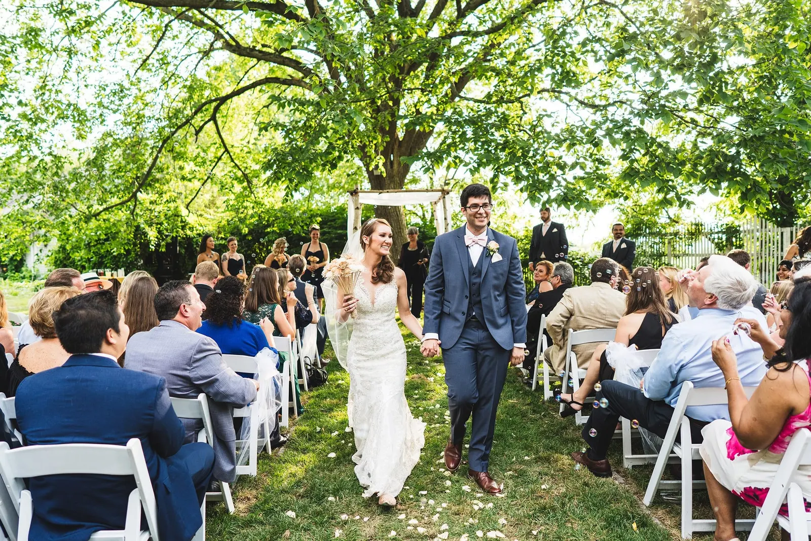 Newlyweds walking up the aisle past cheering guests