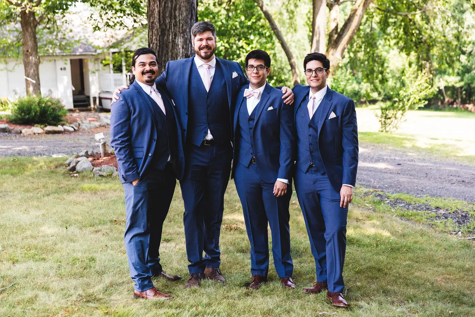 Groom and groomsmen in matching blue suits on the lawn at Feast at Round Hill