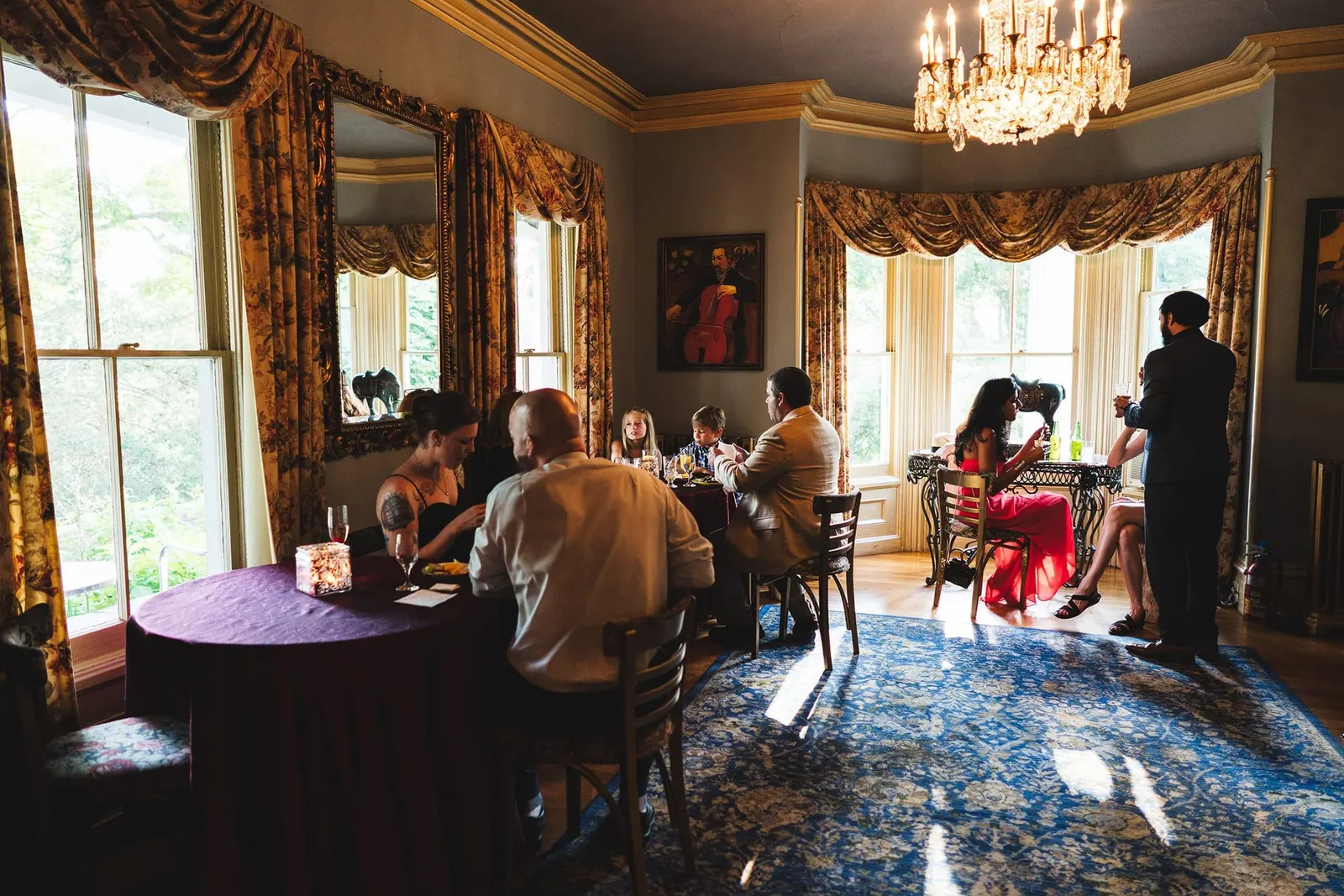 Reception room with a chandelier and garden windows at Feast at Round Hill