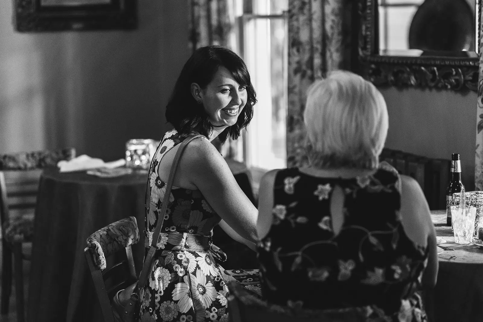 Black and white photo of guests talking at a reception table