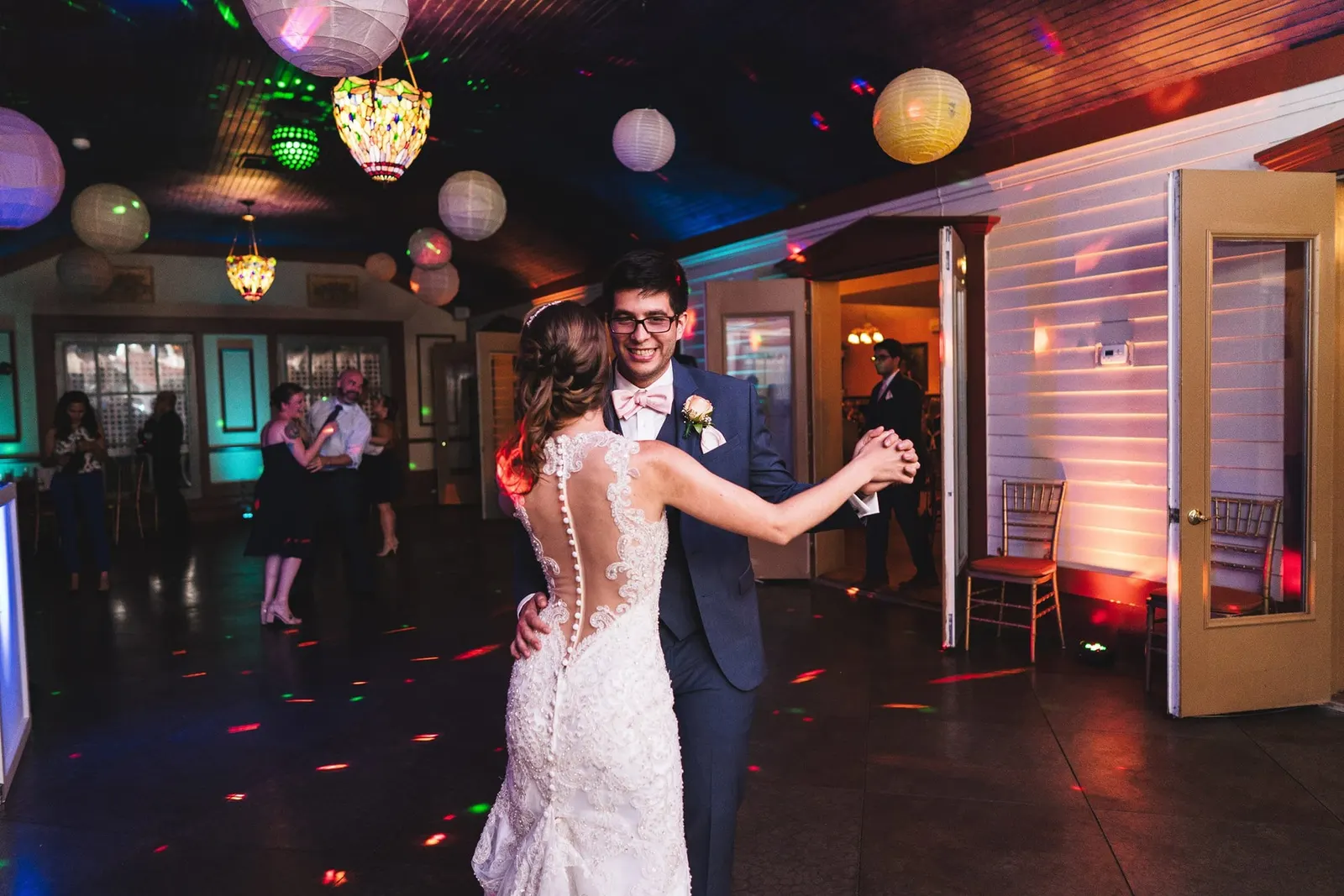Bride and groom dancing under paper lanterns