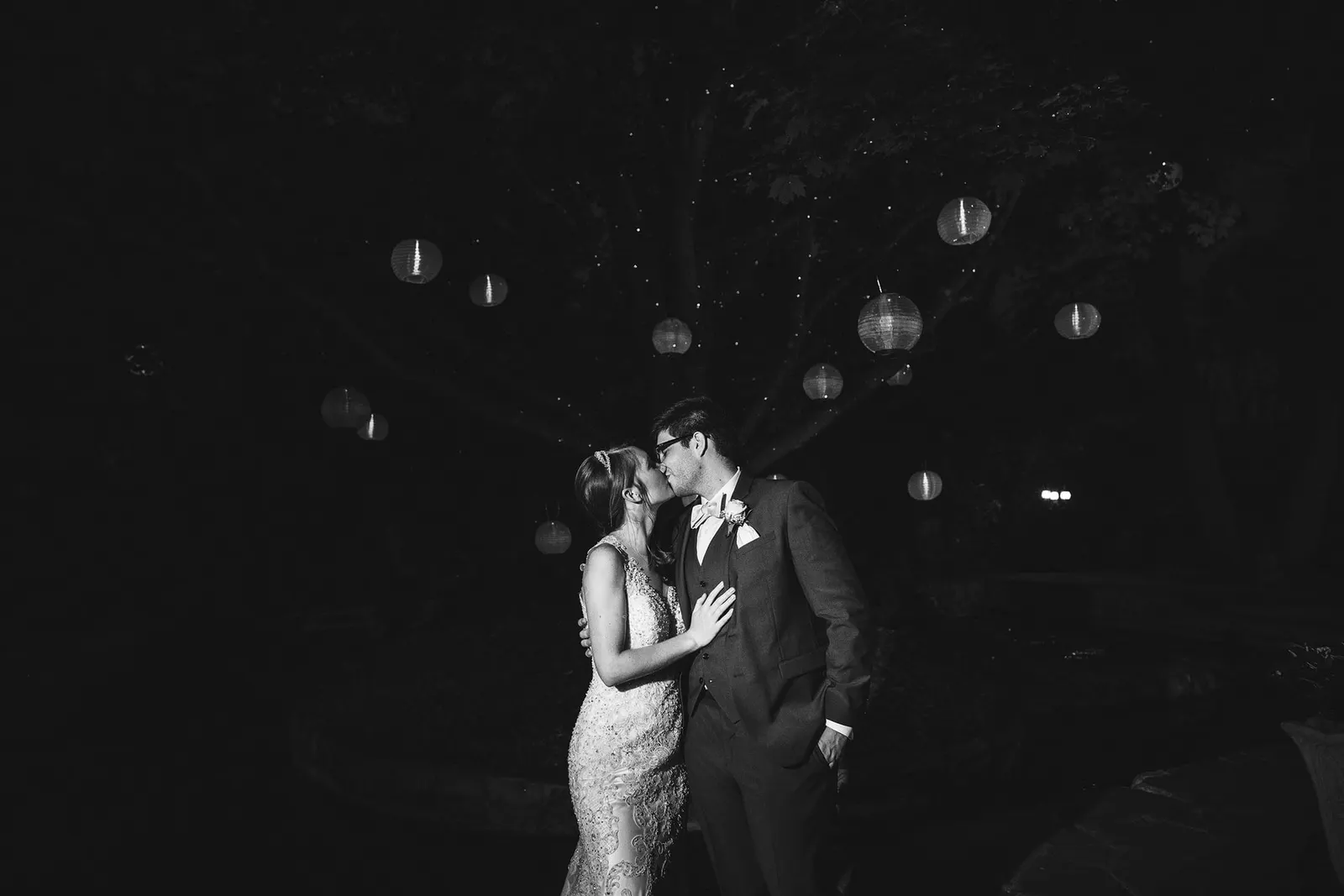 Black and white photo of the newlyweds kissing on the dance floor