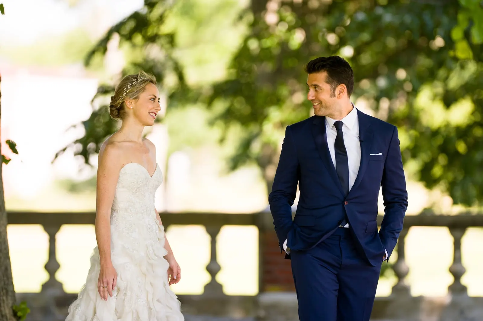 Bride and groom seeing each other for the first time by a stone balustrade