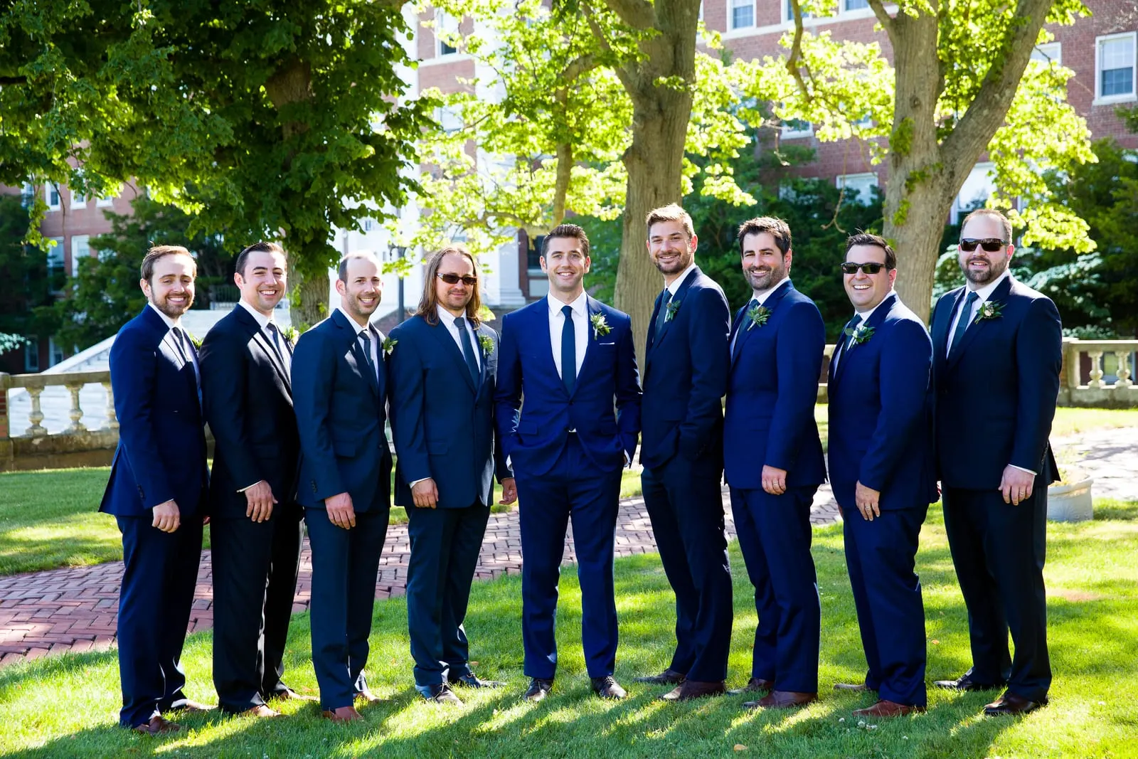 Groom with his groomsmen in navy suits on the lawn