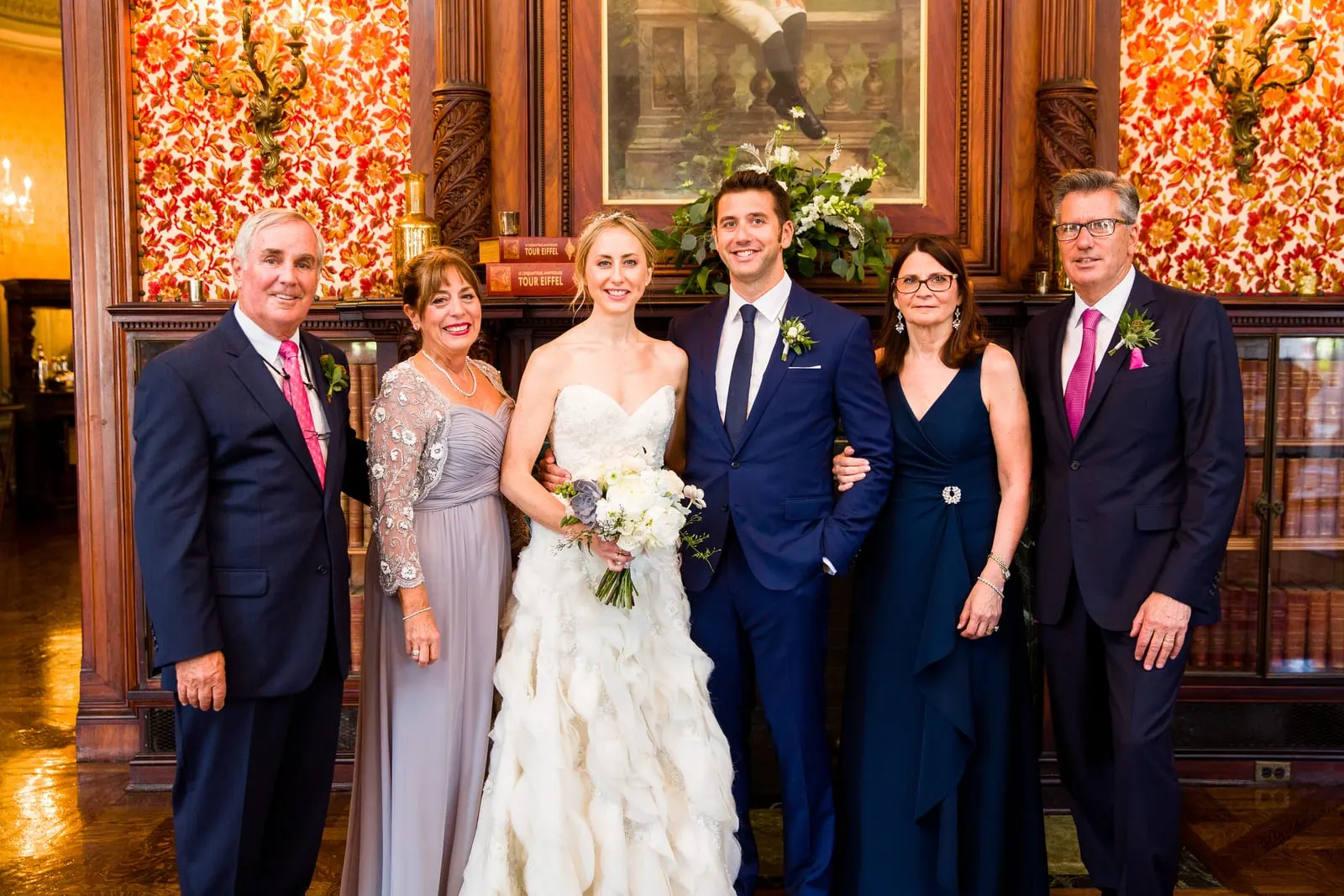 Bride and groom with their parents in the mansion's library