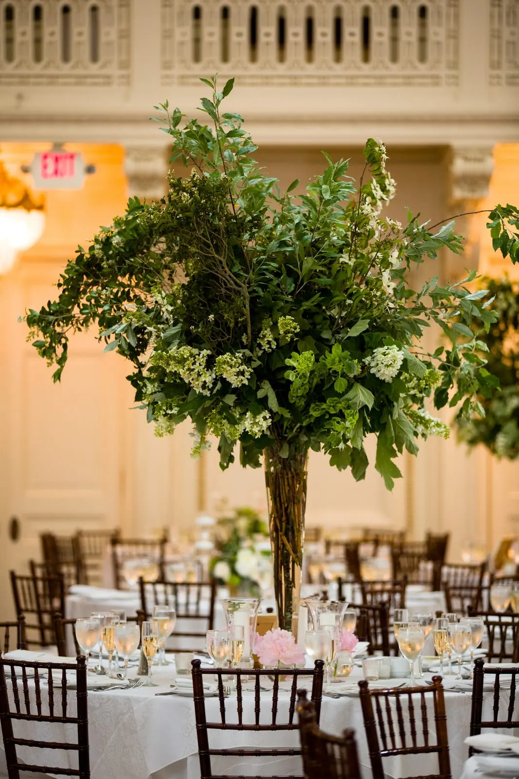 Tall tree centerpiece over a reception table in the ballroom