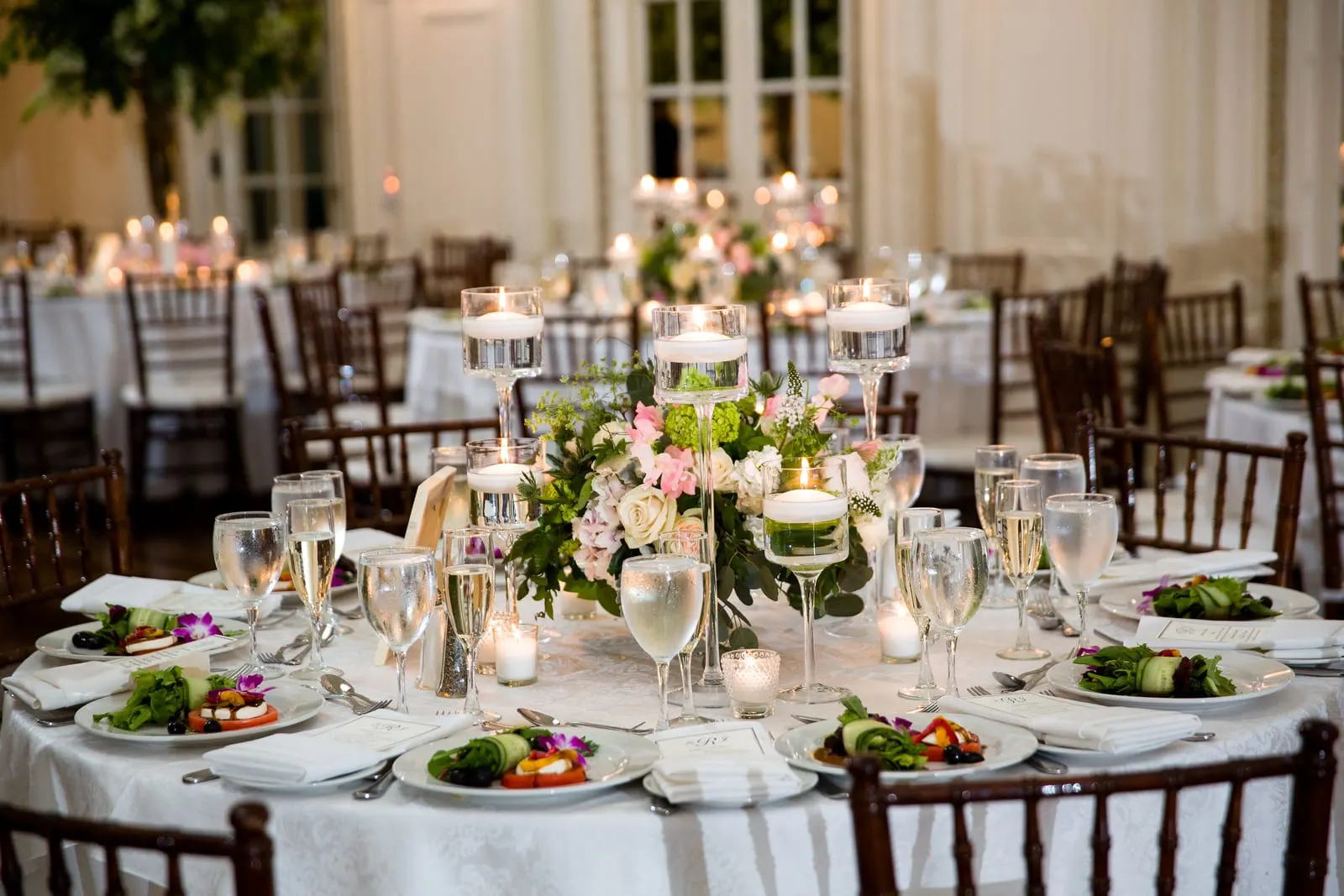 Candlelit reception tables with roses and hydrangeas