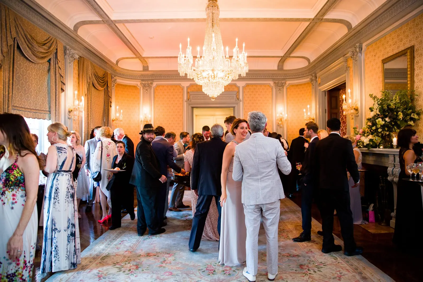 Guests mingling under a crystal chandelier during cocktail hour