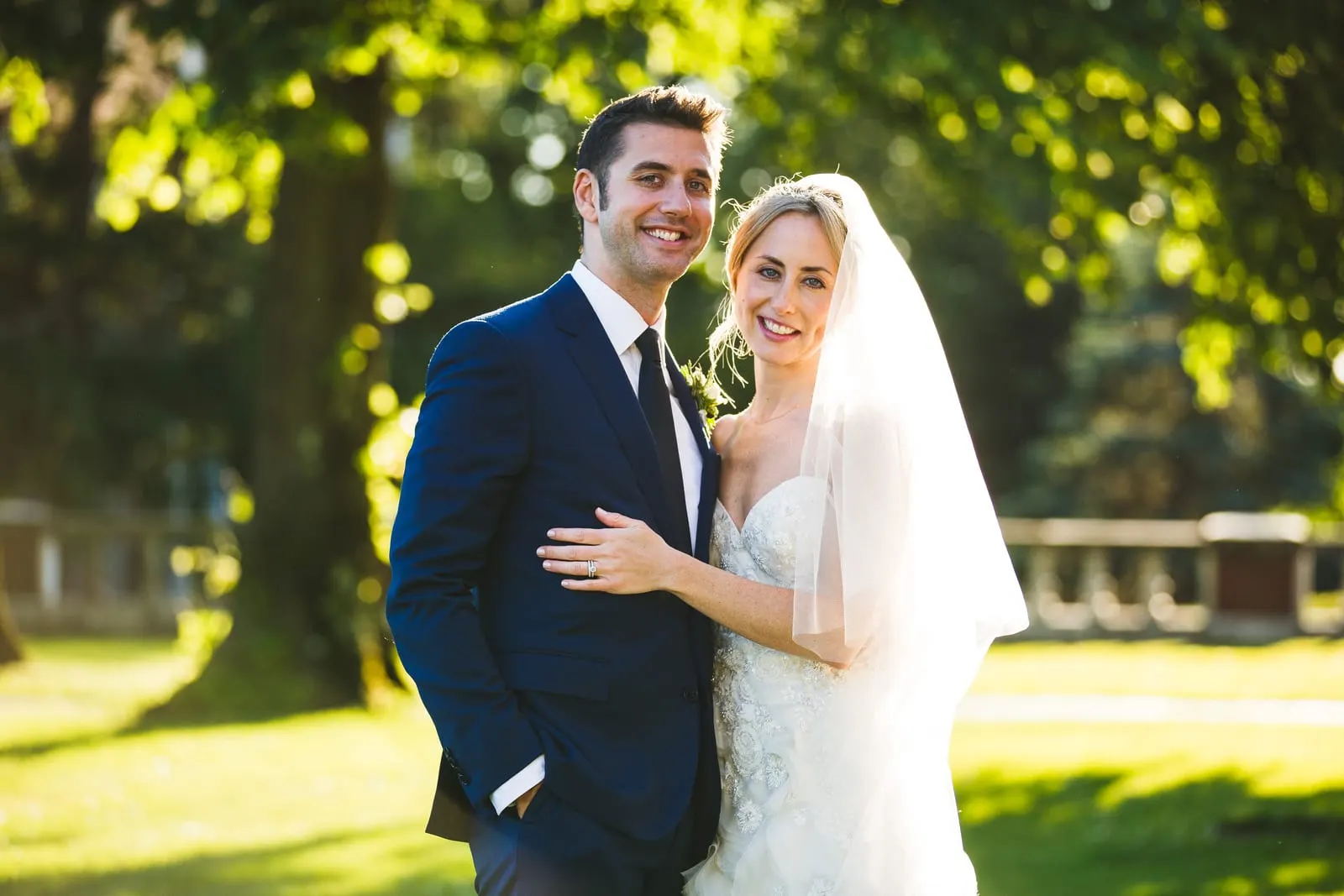 Bride and groom embracing in golden light on the grounds