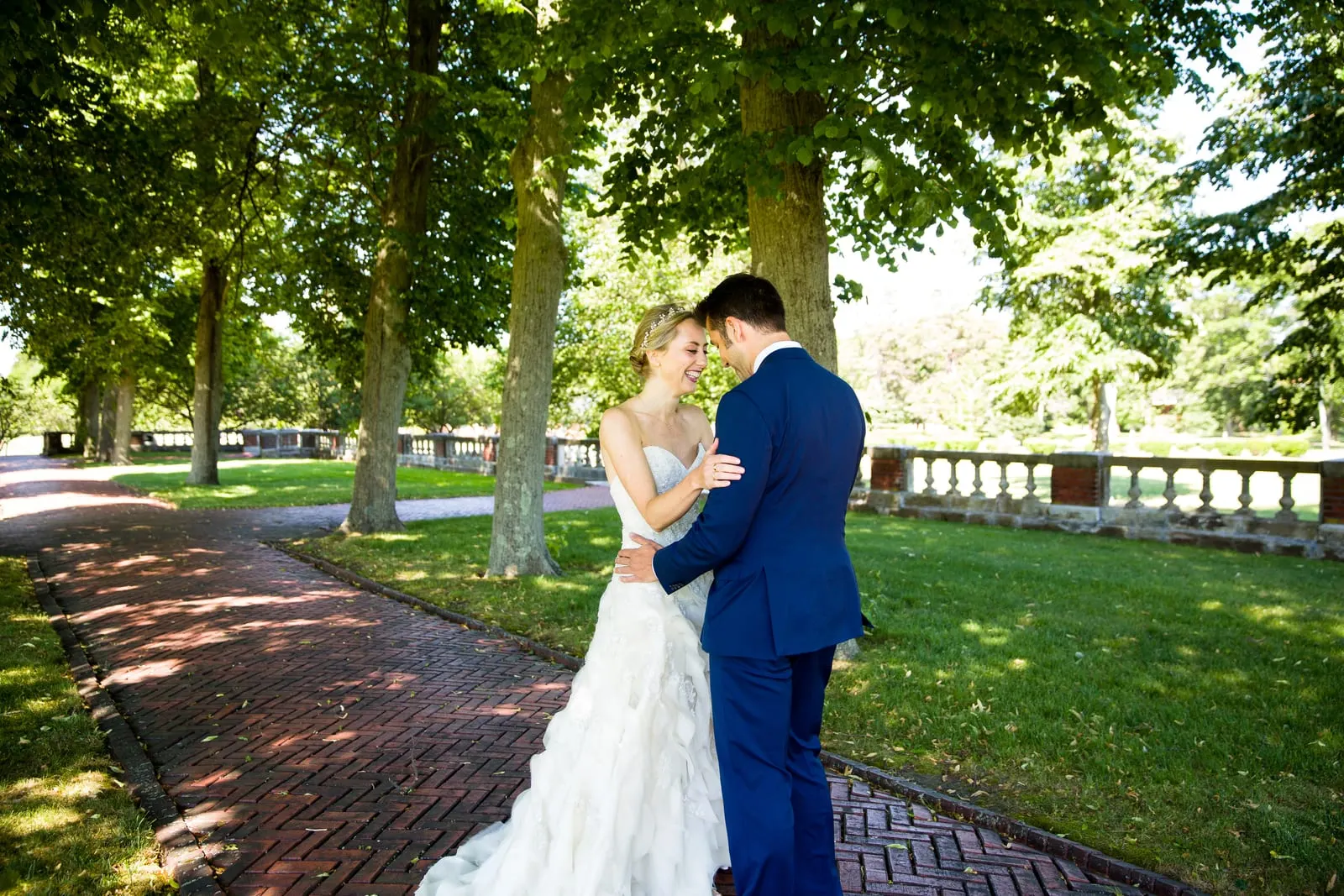 Bride and groom embracing on a tree-lined path