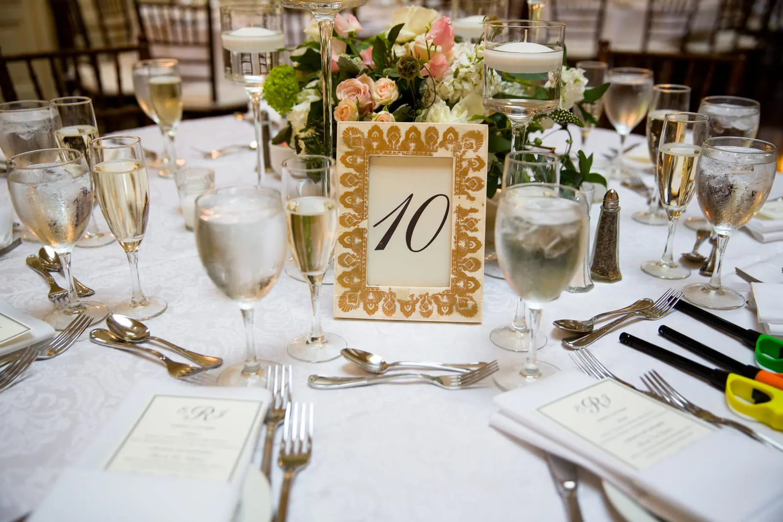 Reception table with a gold table number and glassware