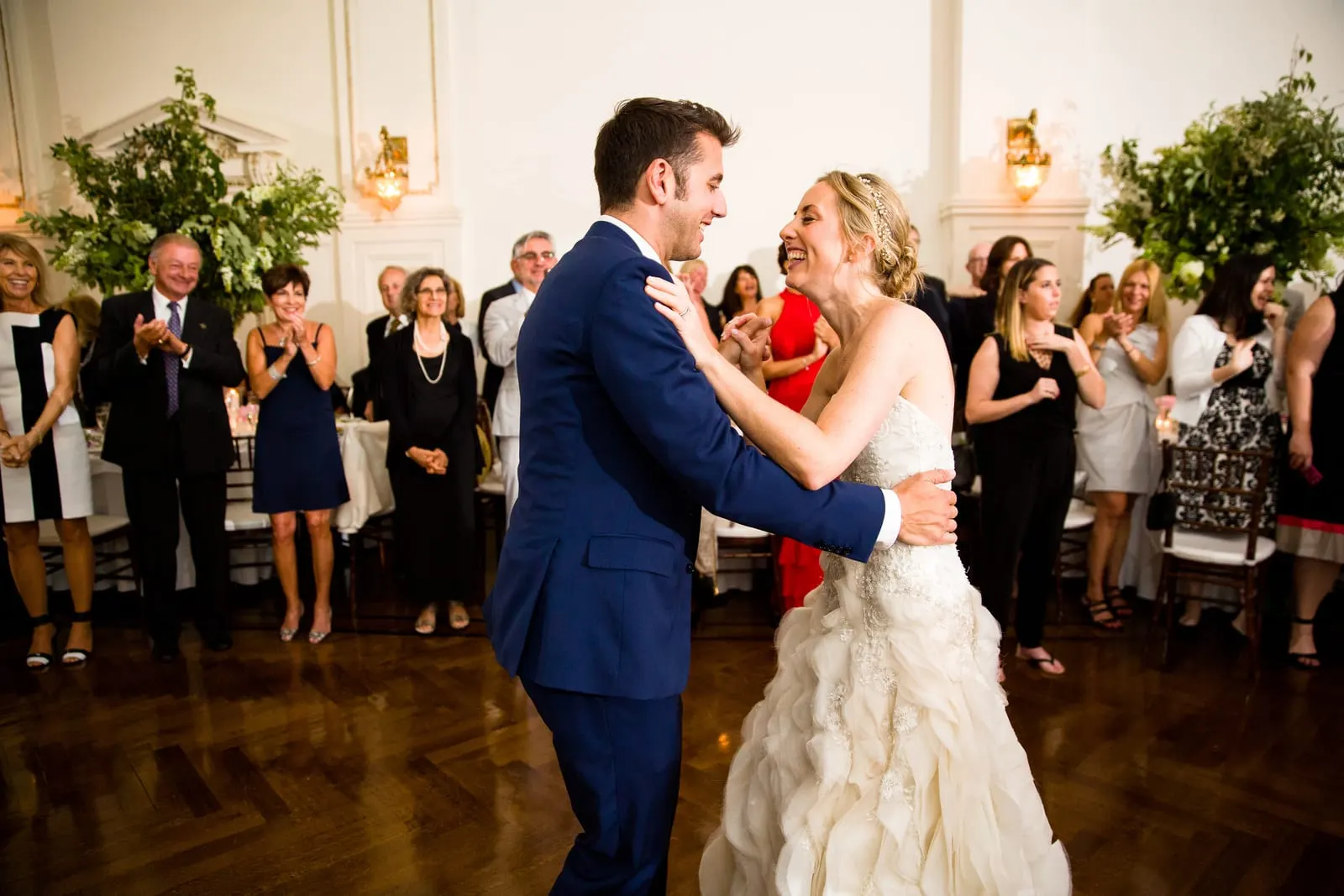 Bride and groom dancing surrounded by guests