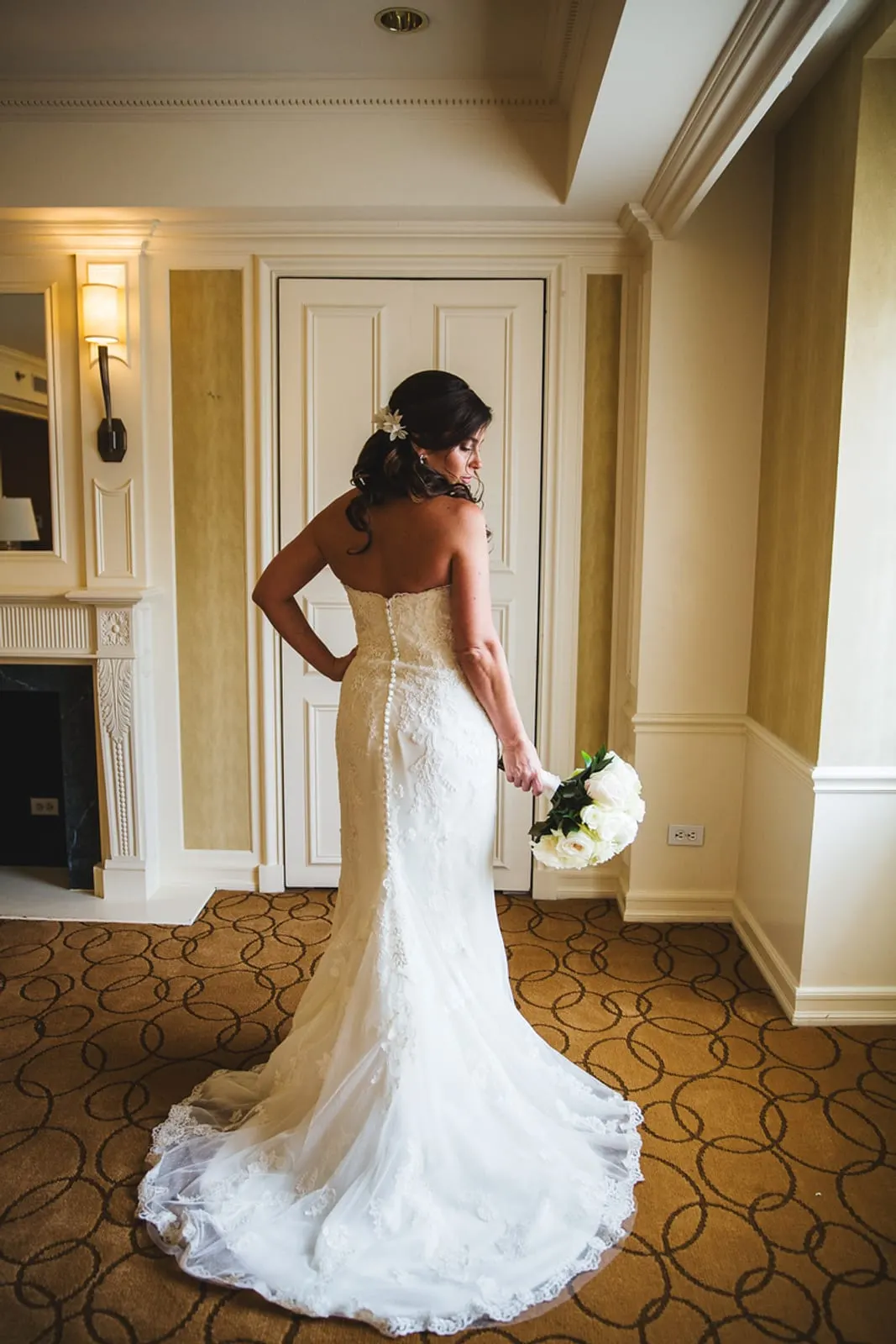 Bride in her lace gown looking back over her shoulder