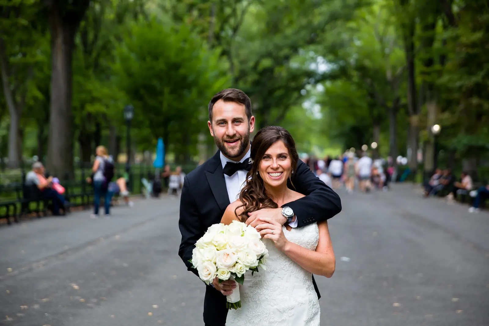 Groom wrapping his arms around the bride on the Mall in Central Park