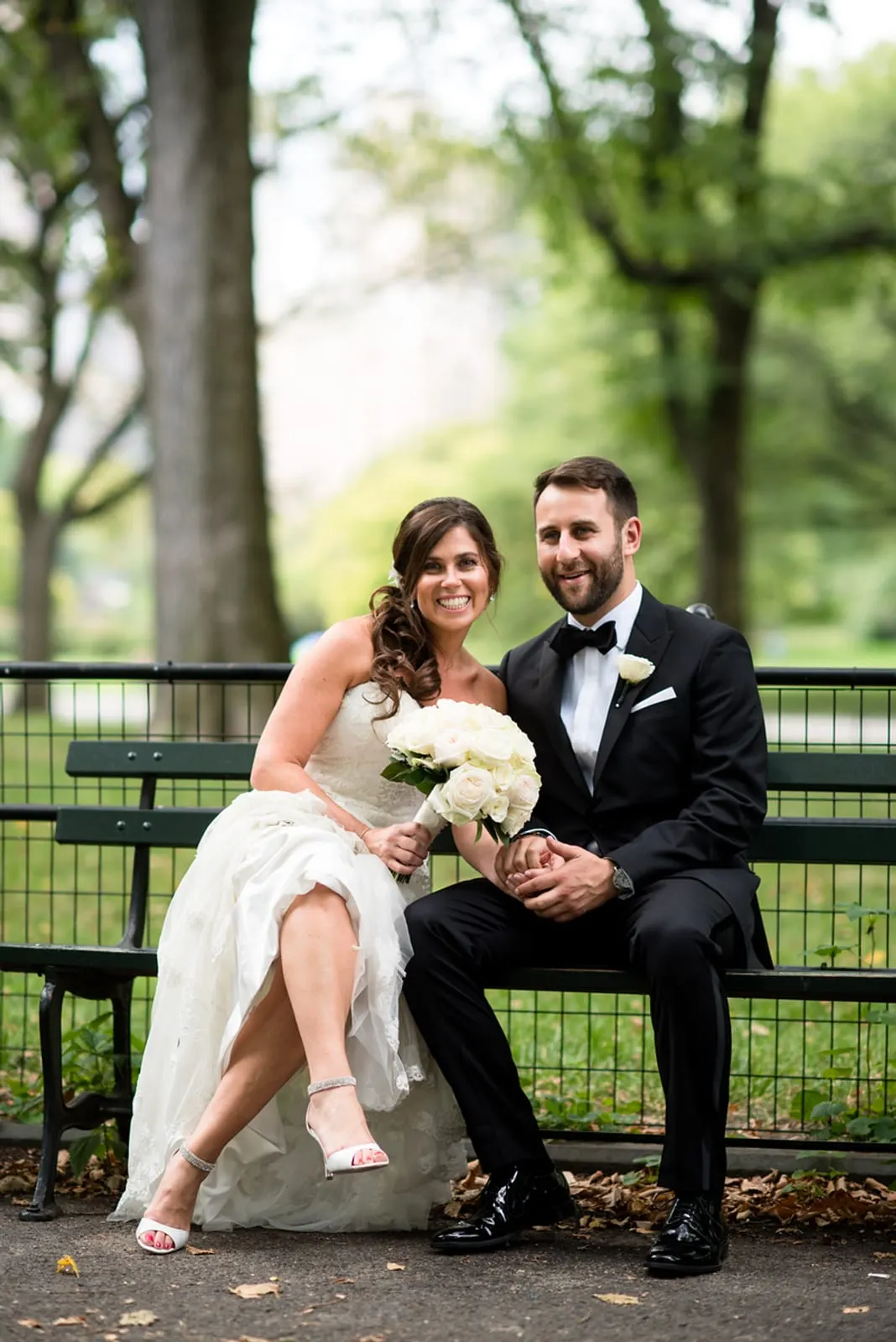 Bride and groom sitting on a park bench in Central Park
