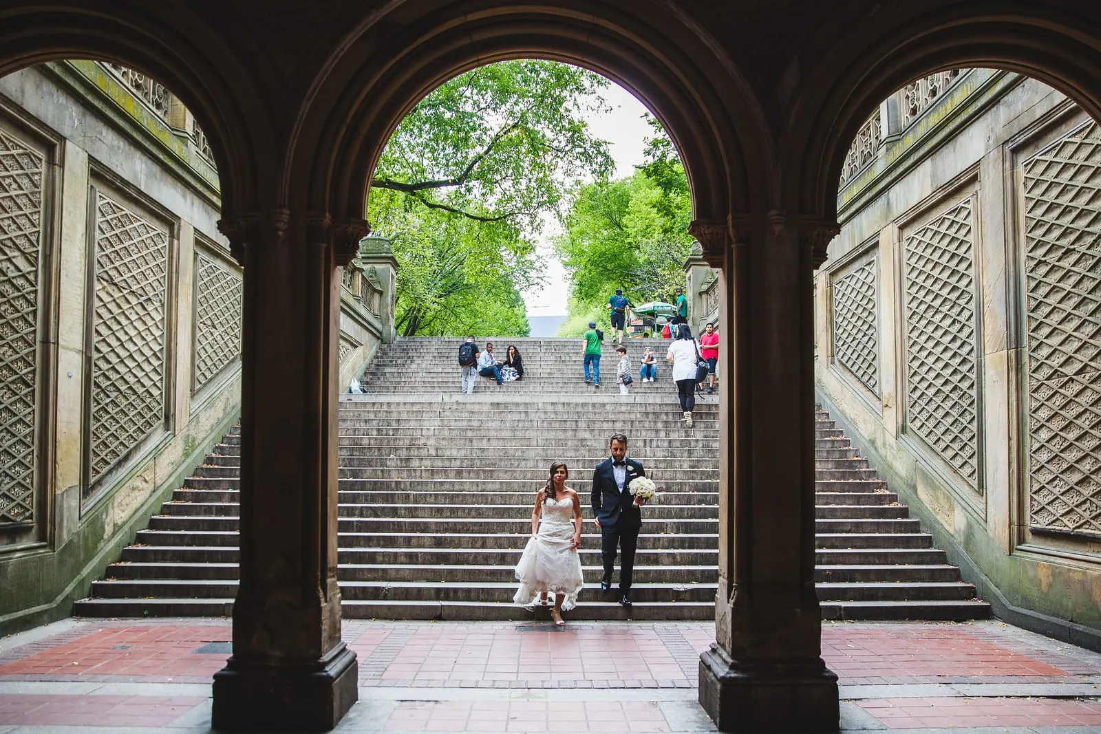 Bride and groom framed by the arches of Bethesda Terrace