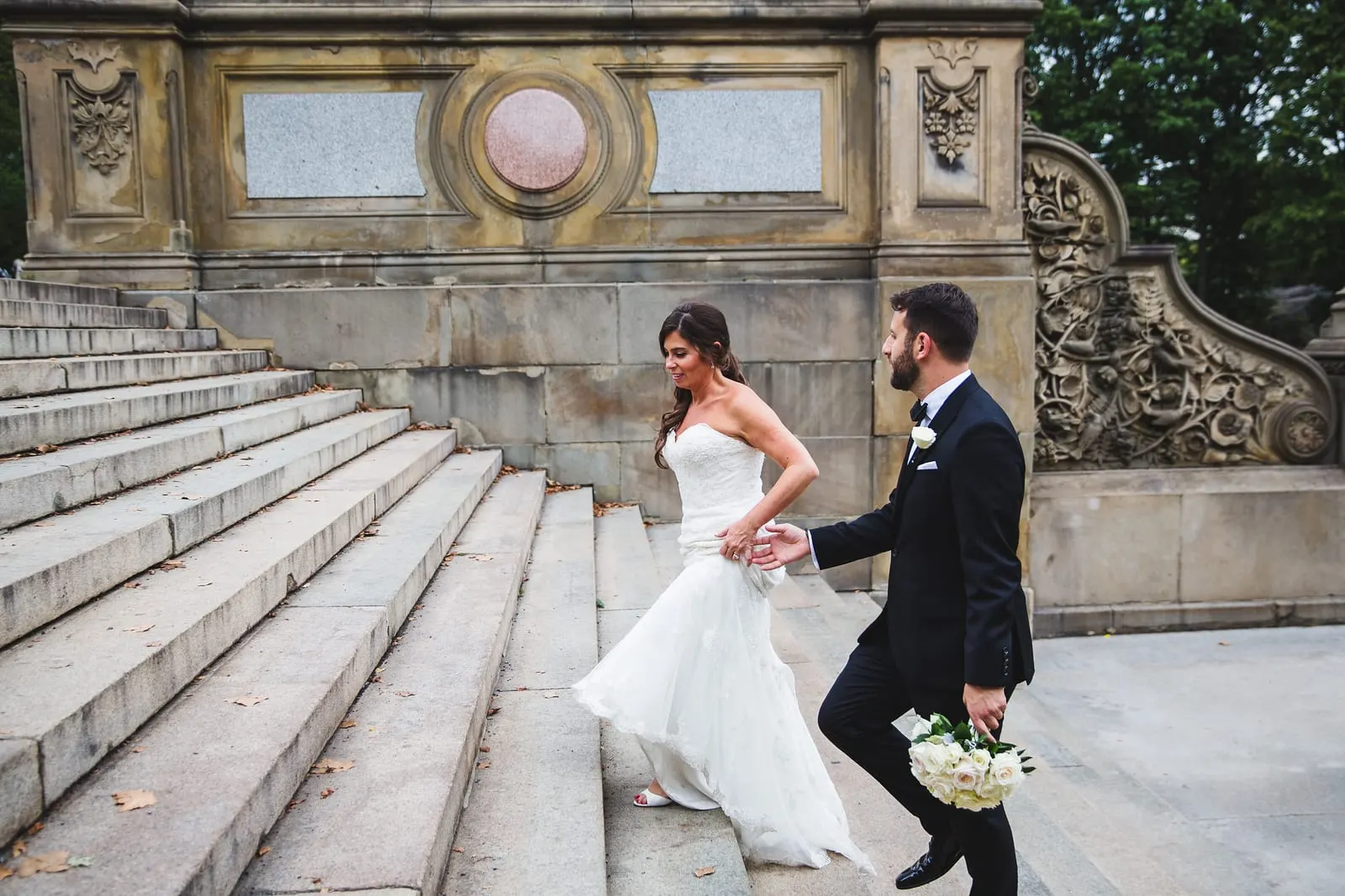 Groom leading the bride up the steps of Bethesda Terrace
