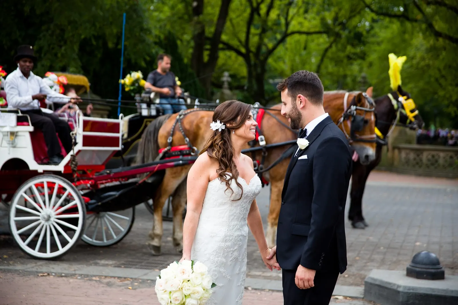 Bride and groom beside a horse carriage on the edge of Central Park