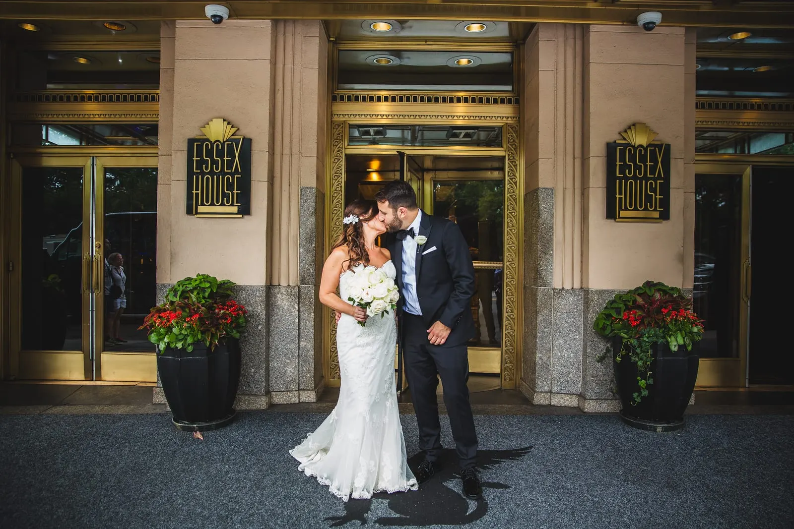 Bride and groom kissing under the Essex House entrance