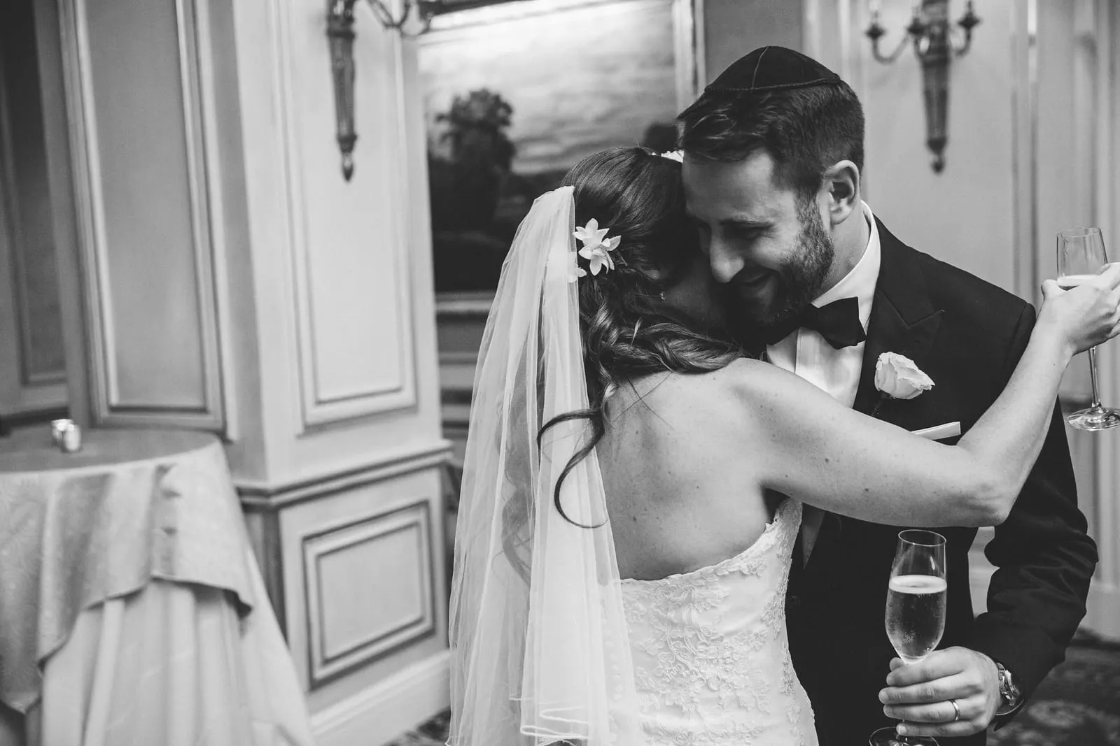 Bride and groom embracing after the ceremony, in black and white