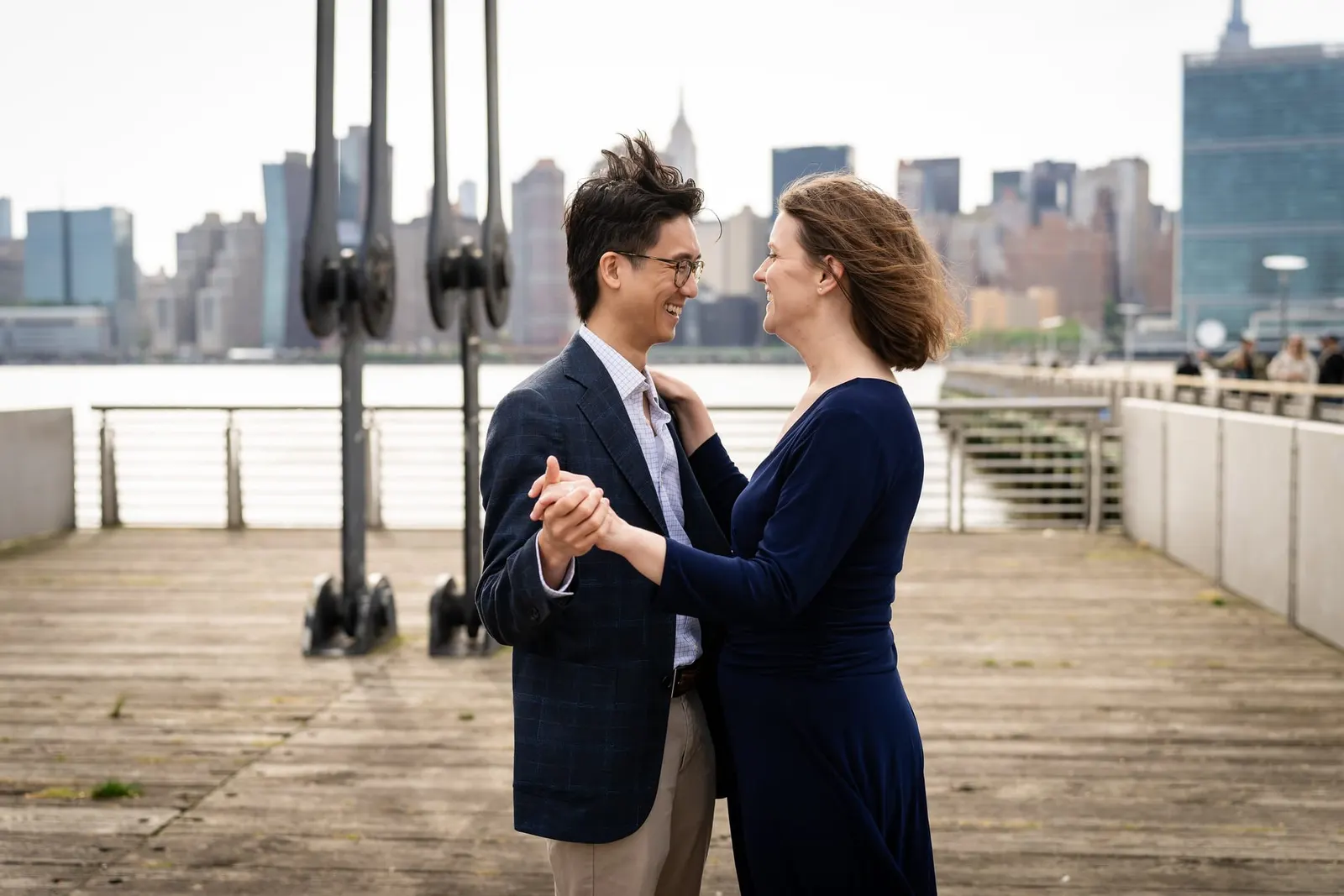 Couple dancing on the pier with the Manhattan skyline behind them