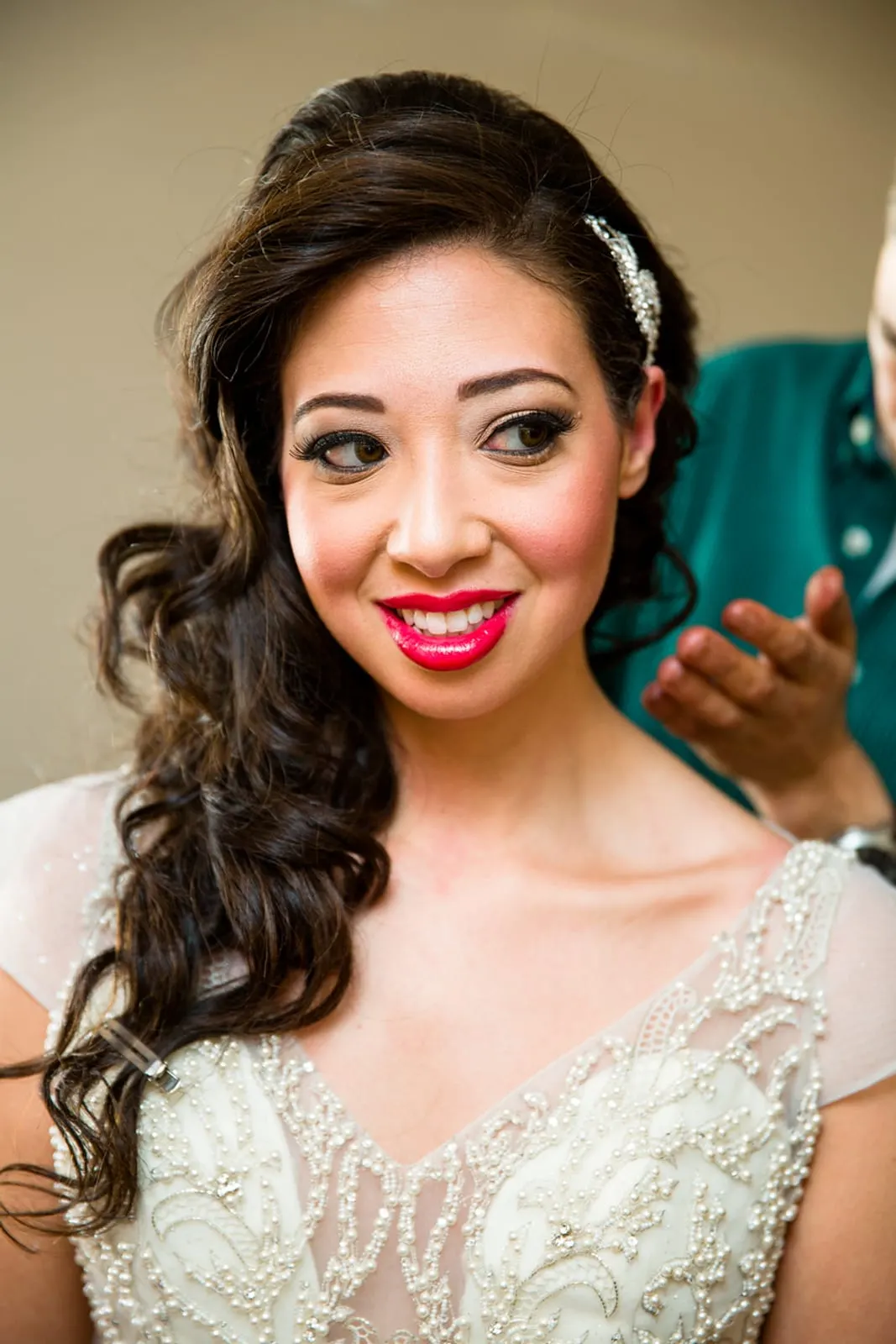Portrait of the bride in her beaded gown with red lips and soft curls