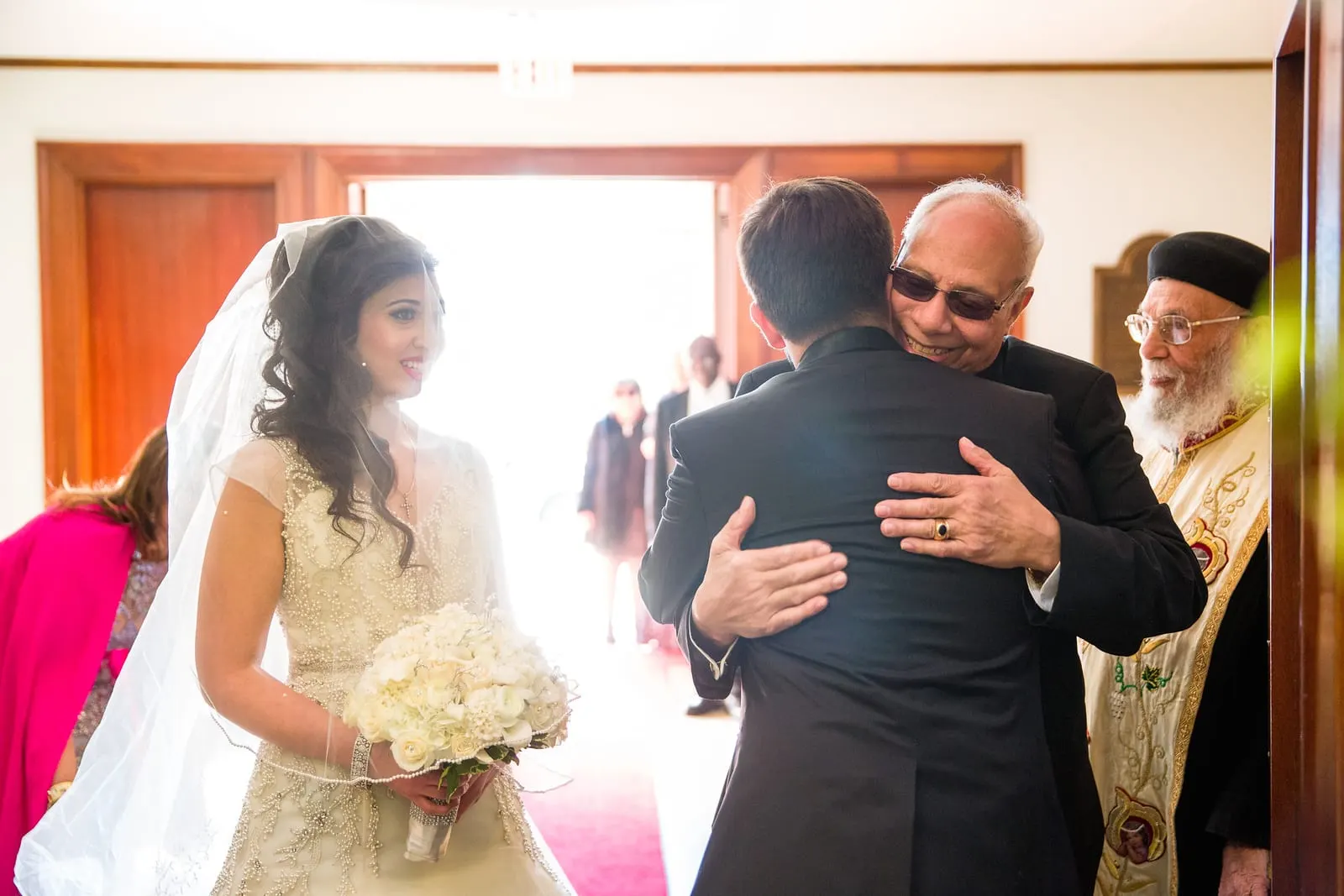Bride's father embracing the groom at the end of the aisle