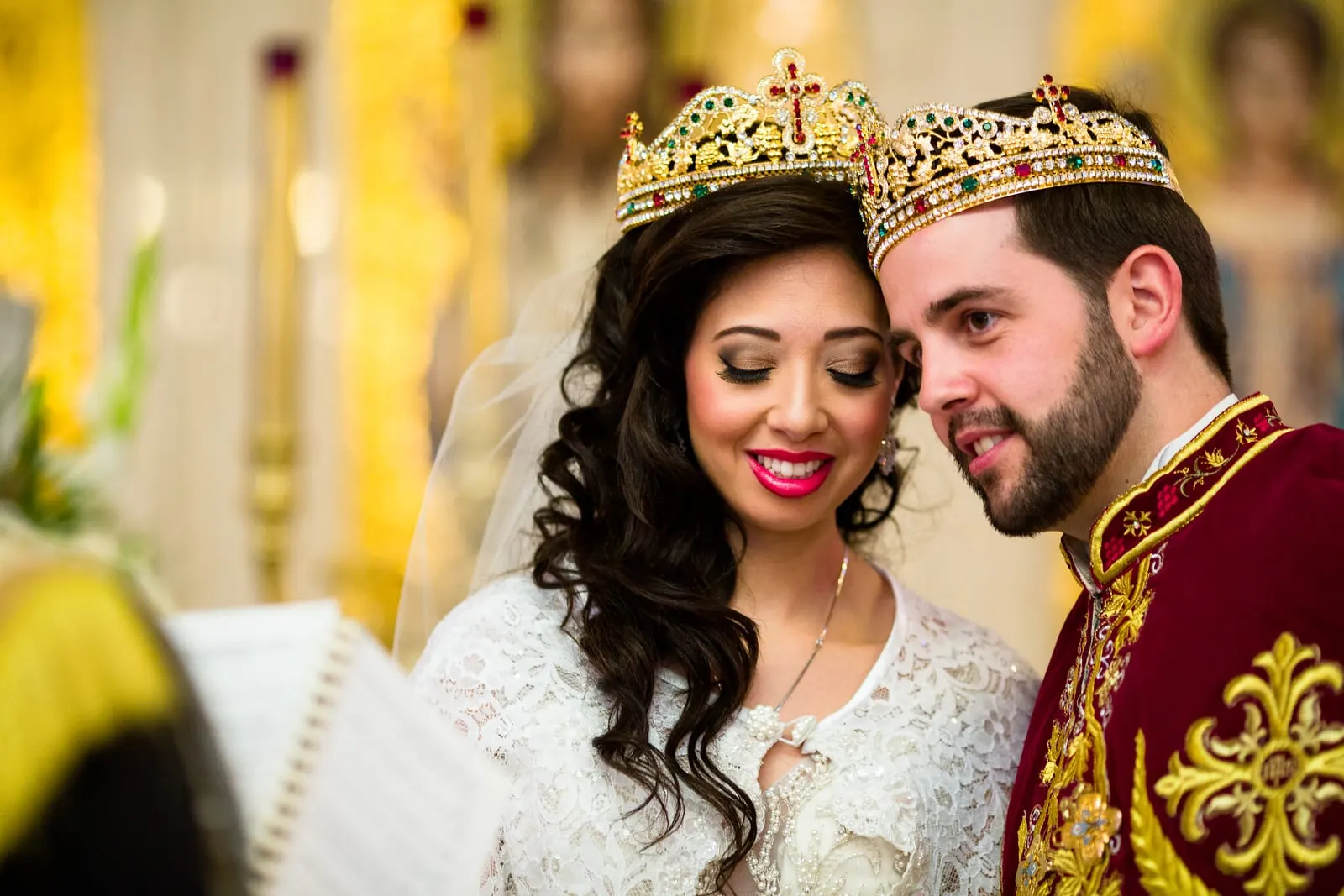 Bride and groom wearing gold crowns during the crowning ceremony
