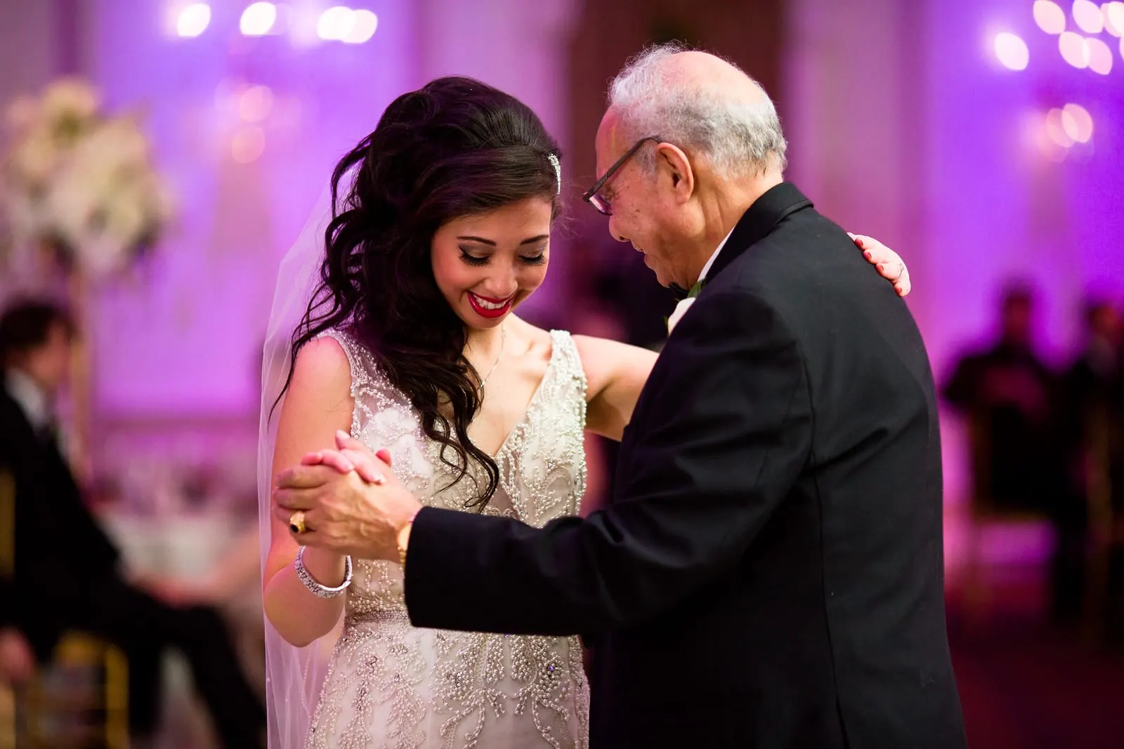 Bride smiling as she dances with her father
