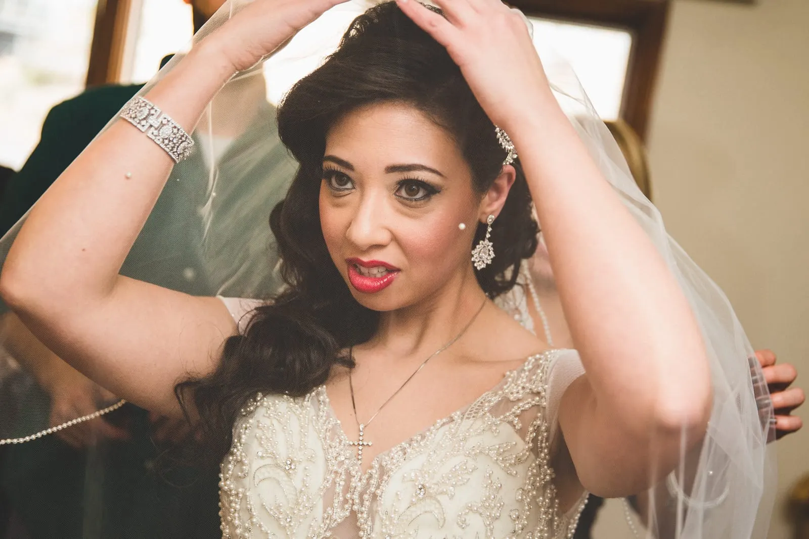 Bride lifting her veil into place