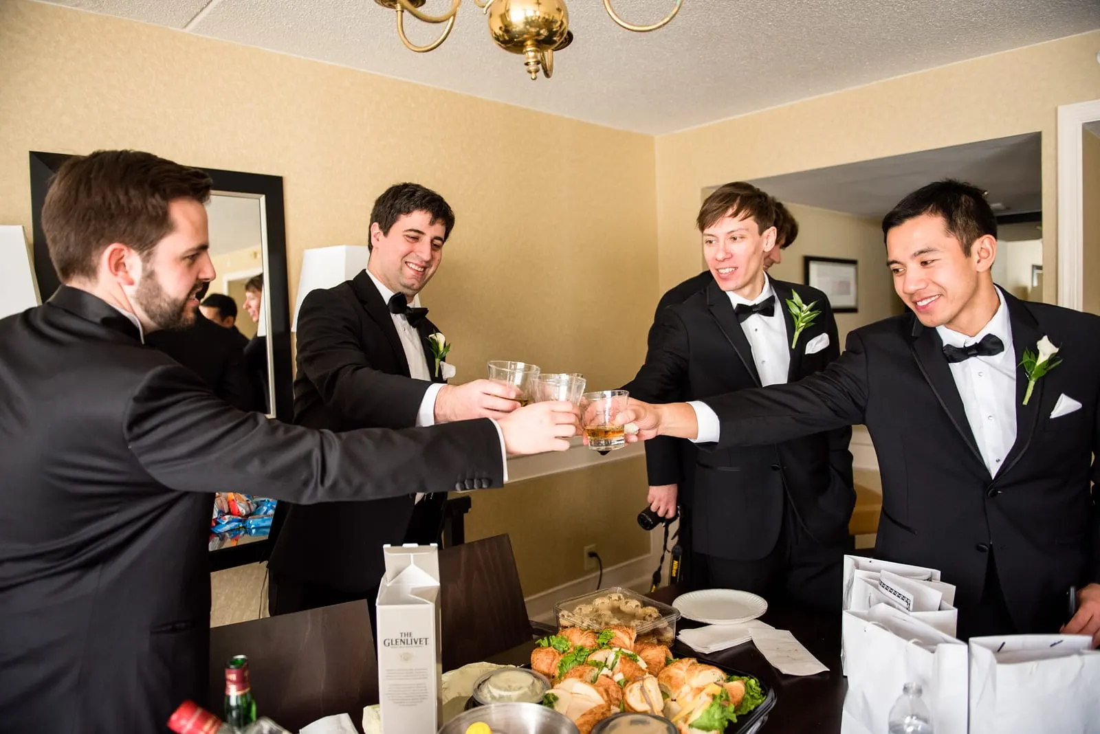 Groom and his groomsmen raising a toast before the ceremony