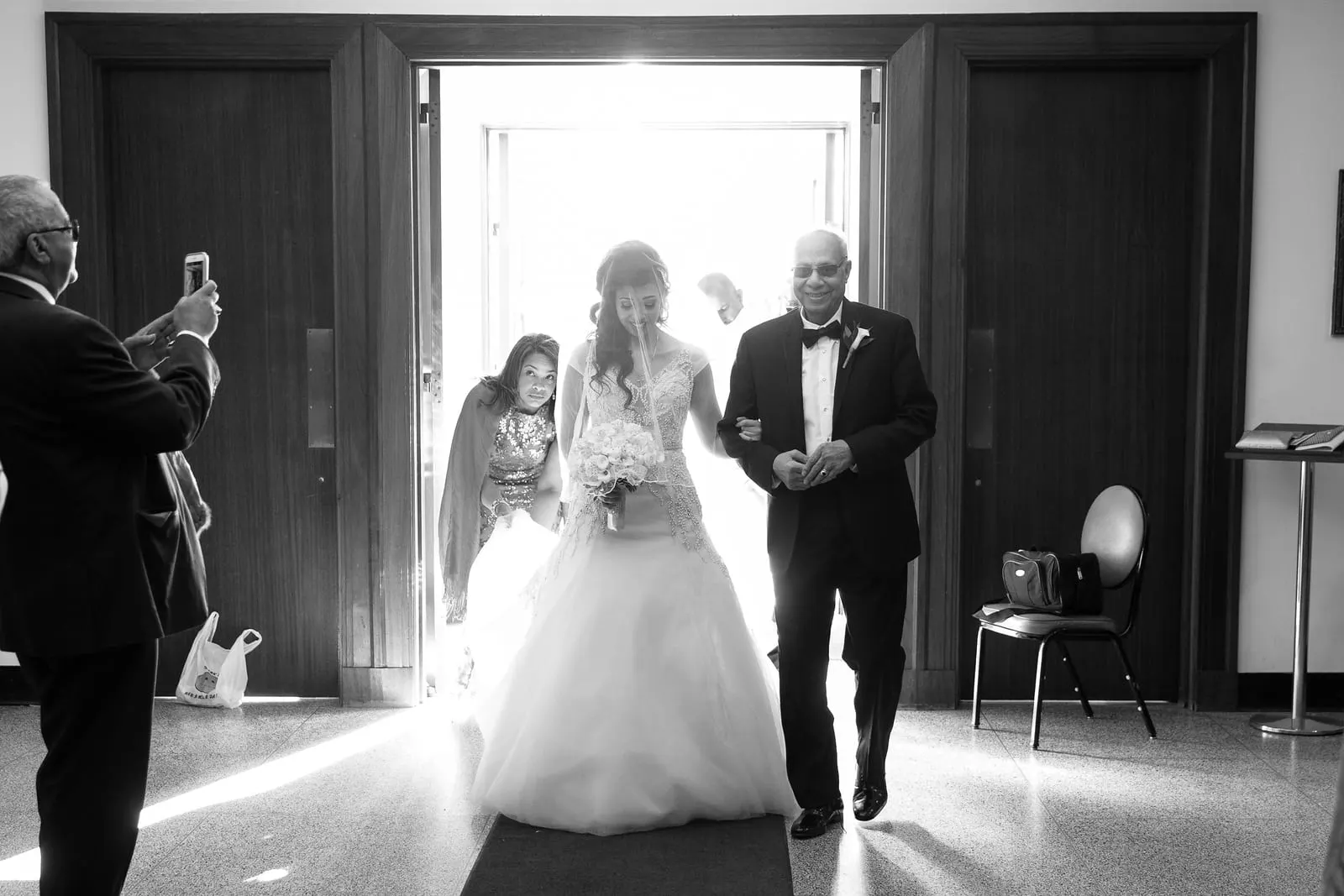 Bride entering the cathedral with her father, in black and white