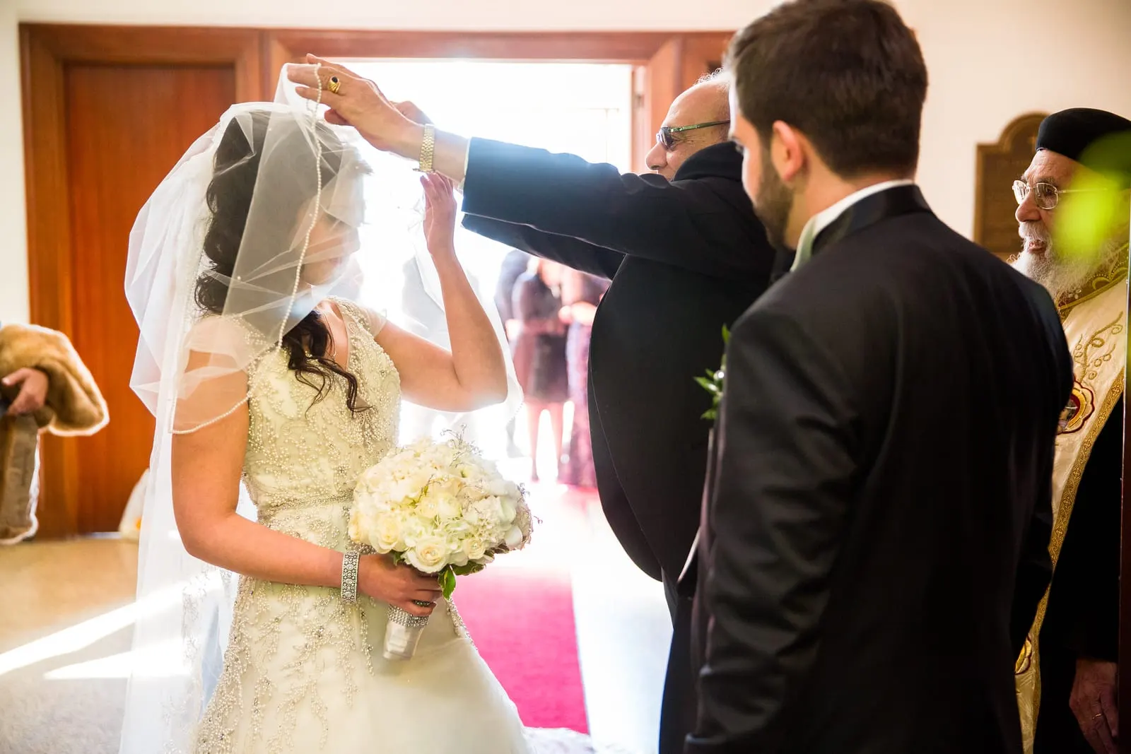 Bride's father lifting her veil at the altar