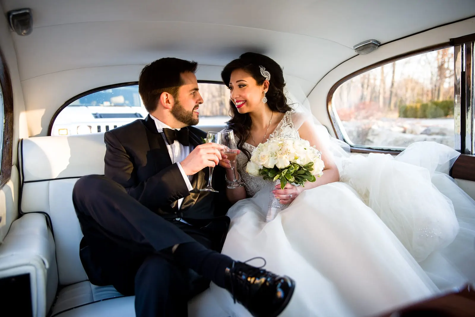 Newlyweds toasting in the back seat of the vintage car